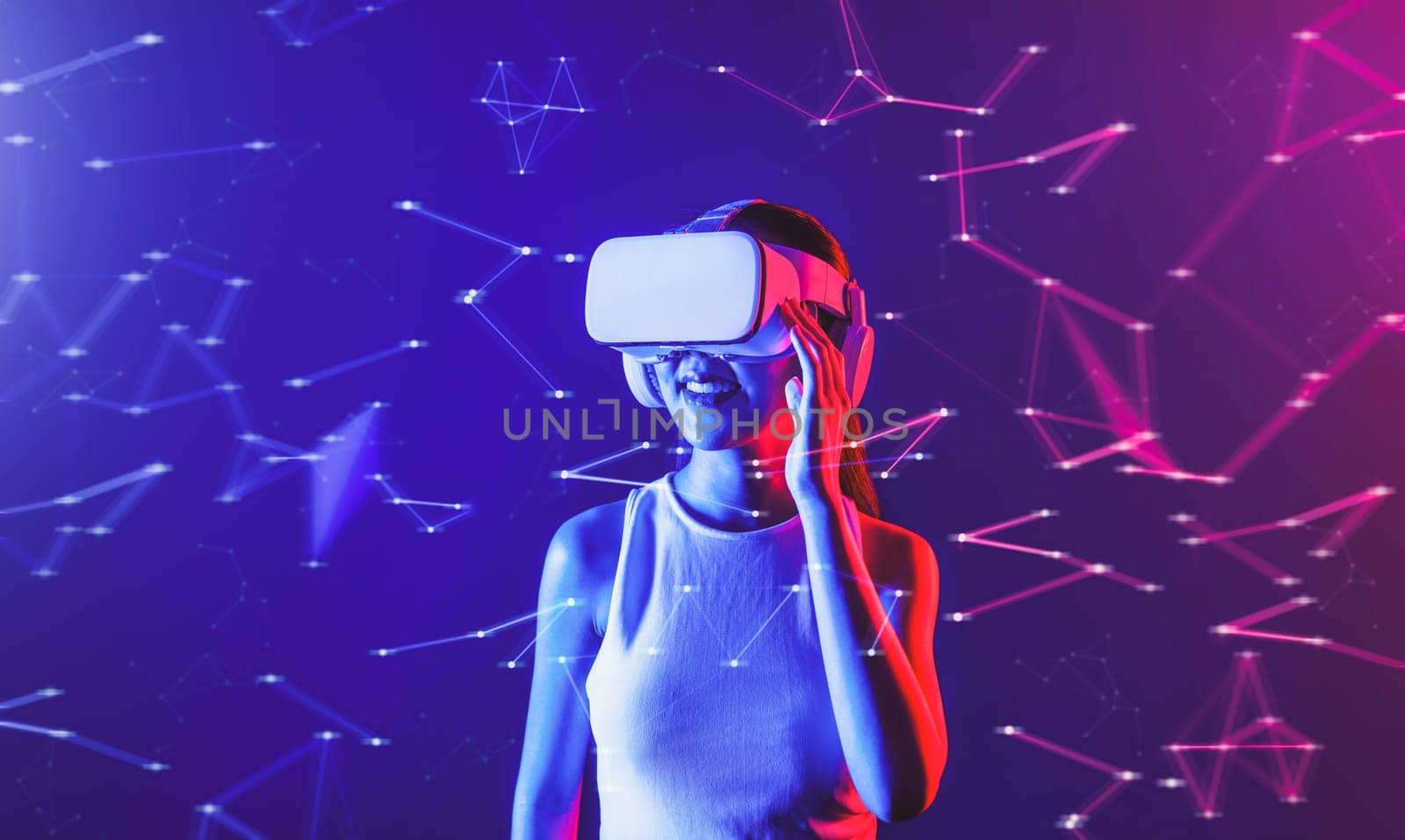 Female stand in cyberpunk neon light wear white VR headset and tank top connecting metaverse, future cyberspace community technology, She look in virtual reality object holding goggles. Hallucination.