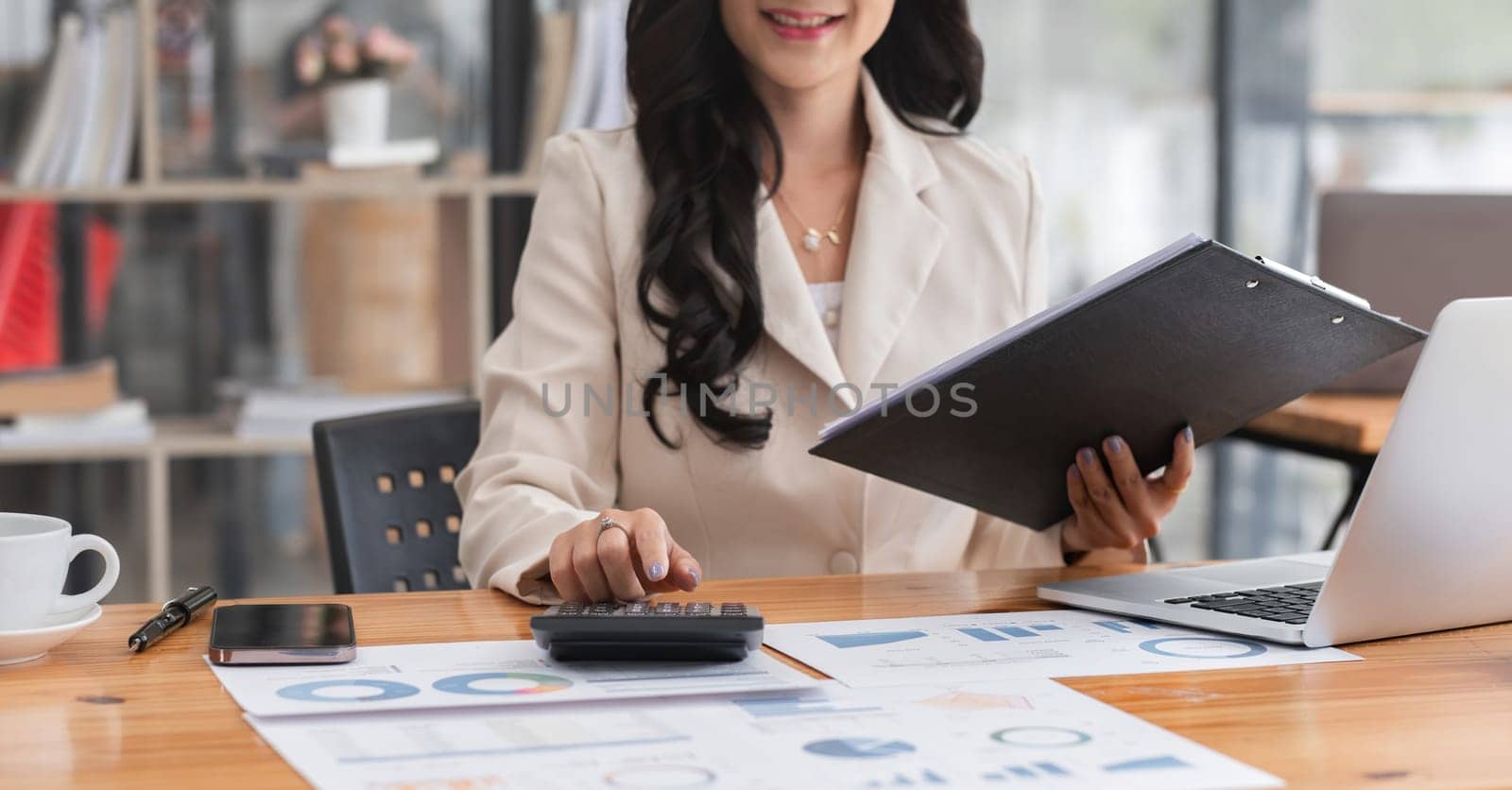 Close-up view of Asian businesswoman working online and planning financial calculation data working from home. Businesswoman and business planner concept by wichayada