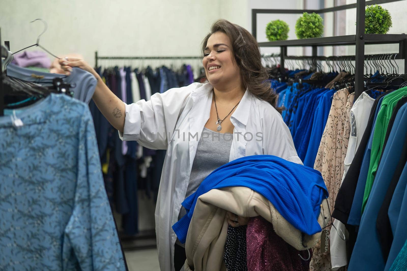 A fat woman chooses clothes in a plus size store. by mrwed54