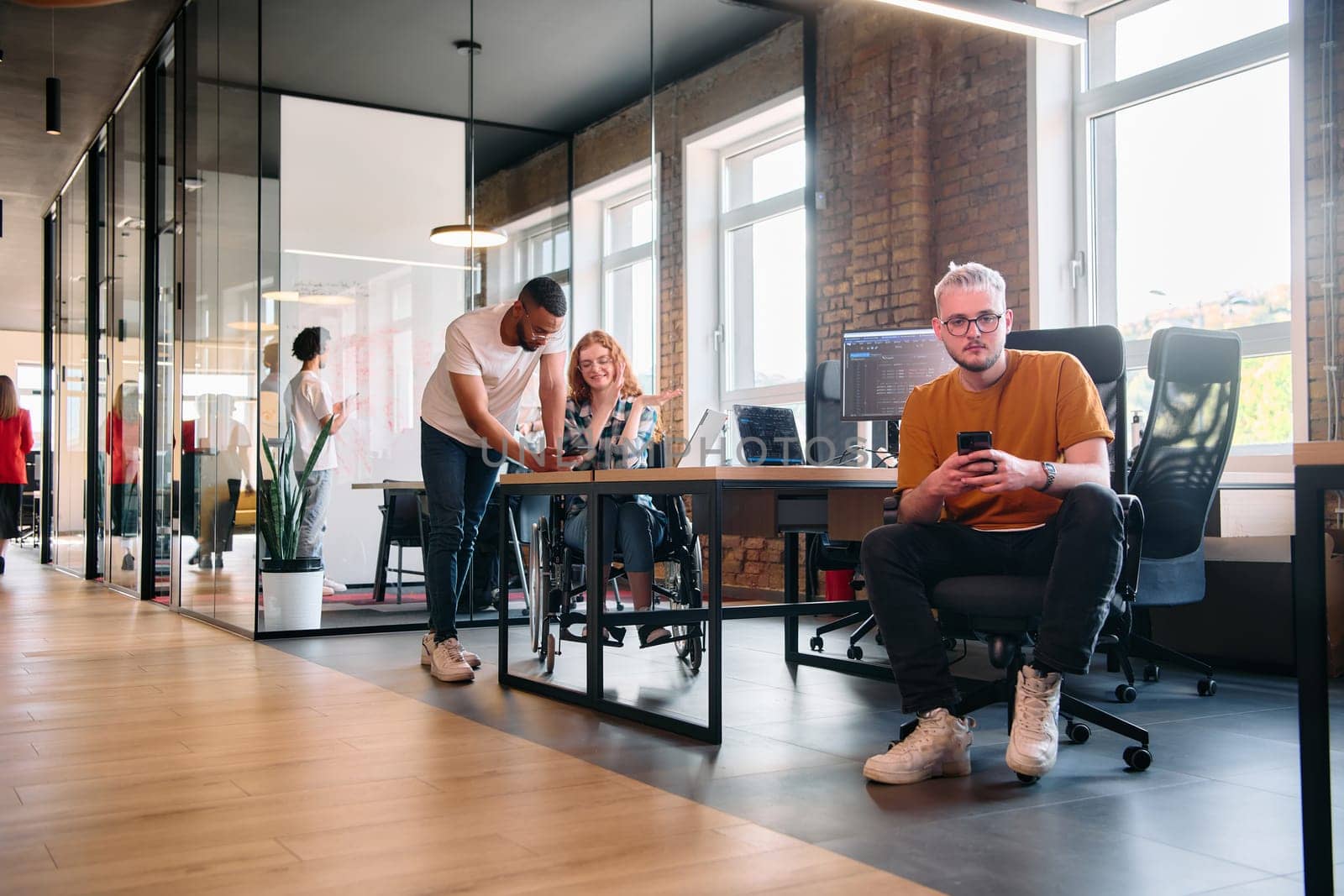 A diverse group of business professionals collaborates in a modern startup coworking center, utilizing a mix of paper-based and technological tools such as mobile phones and computers by dotshock