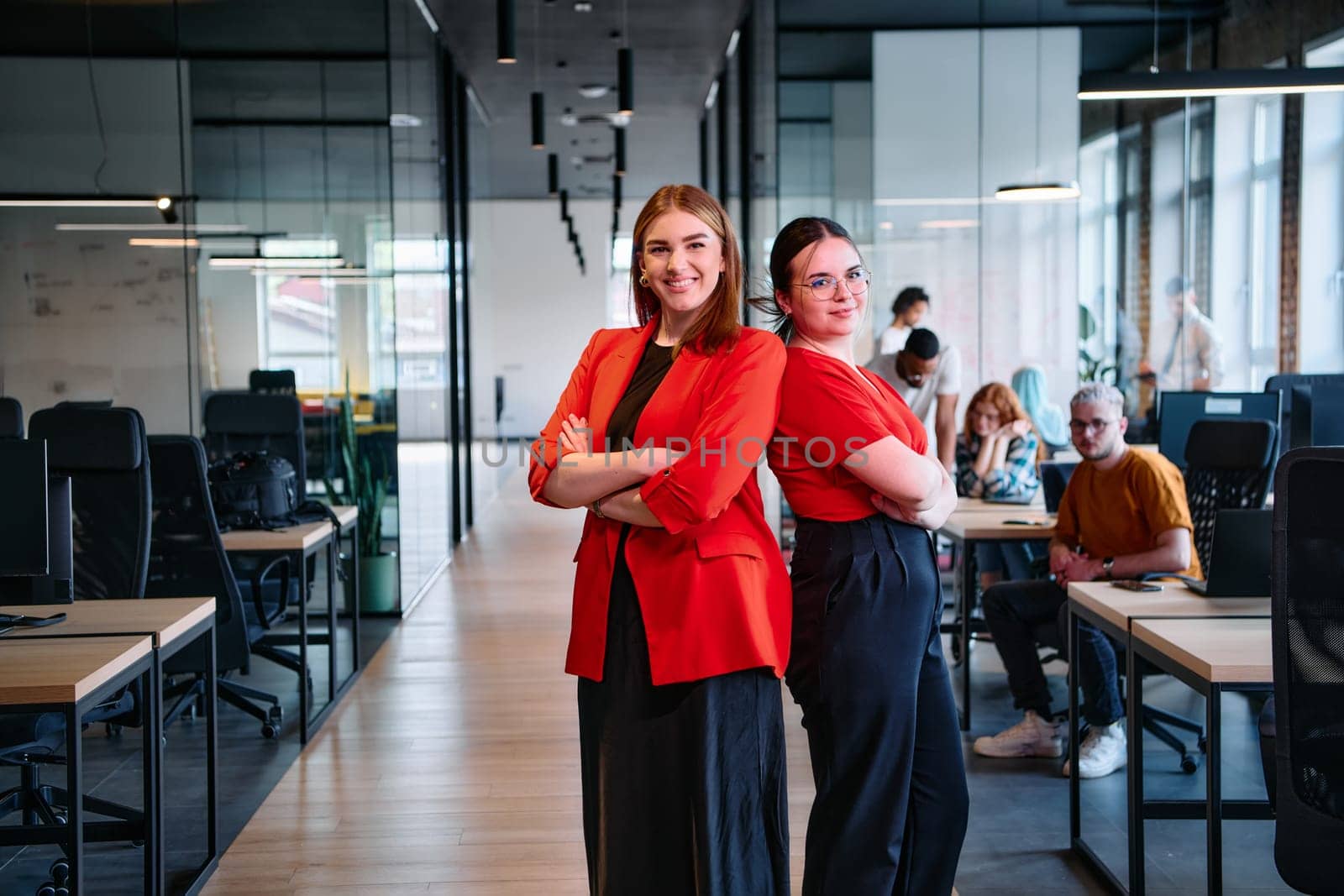 Group of determined businesswomen confidently pose side by side in a modern startup coworking center, embodying professionalism and empowerment by dotshock