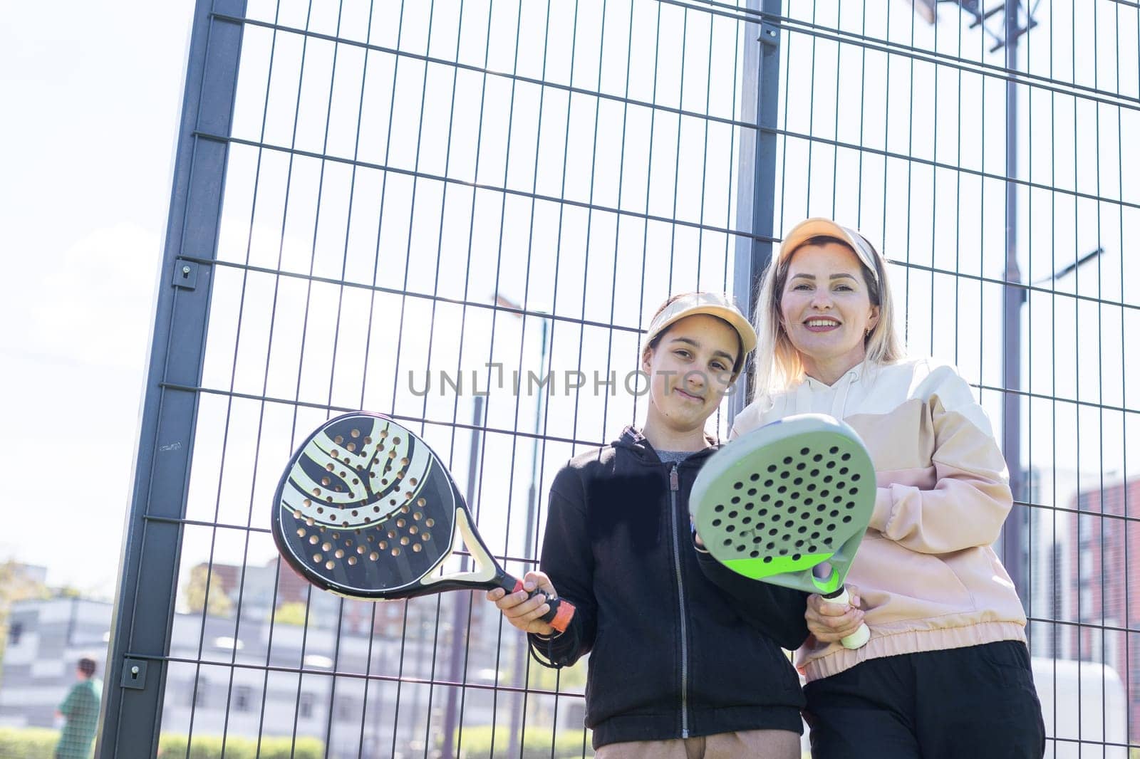 mother and daughter playing padel outdoor by Andelov13