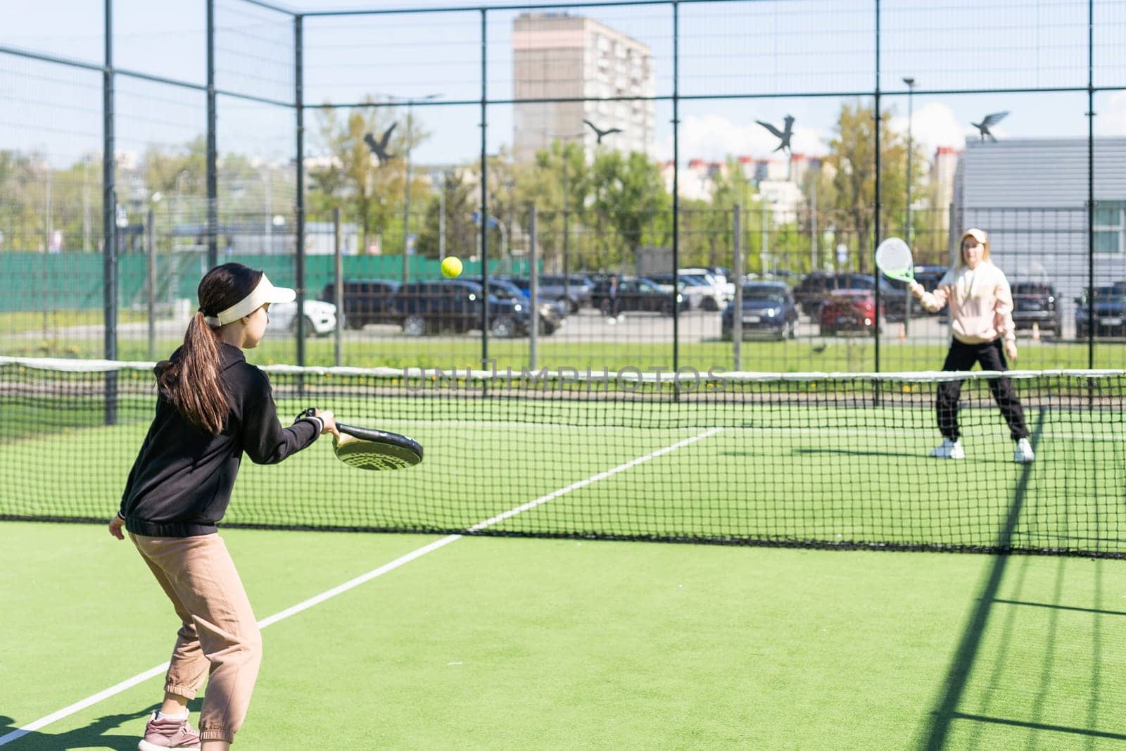 mother and daughter playing padel outdoor. High quality photo