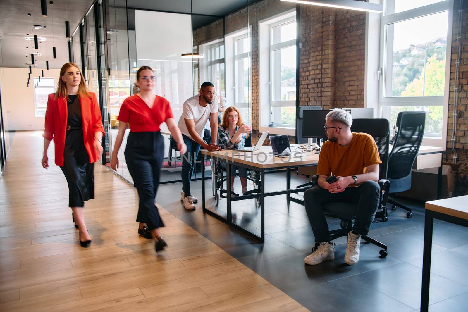 A diverse group of business professionals collaborates in a modern startup coworking center, utilizing a mix of paper-based and technological tools such as mobile phones and computers to collectively tackle a range of business challenges.