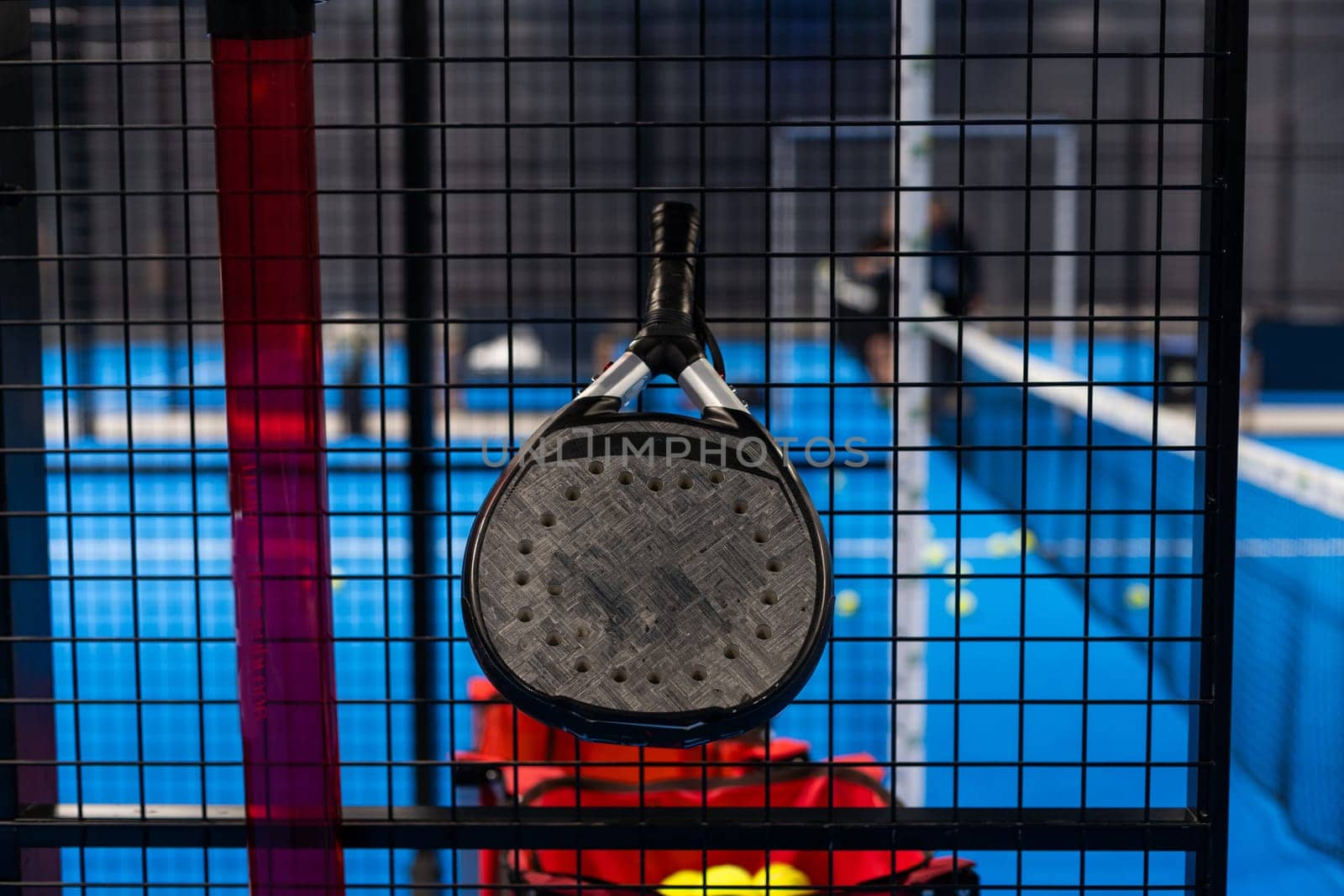 Black professional paddle tennis racket and ball with natural lighting on blue background. Horizontal sport theme poster, greeting cards, headers, website and app. High quality photo