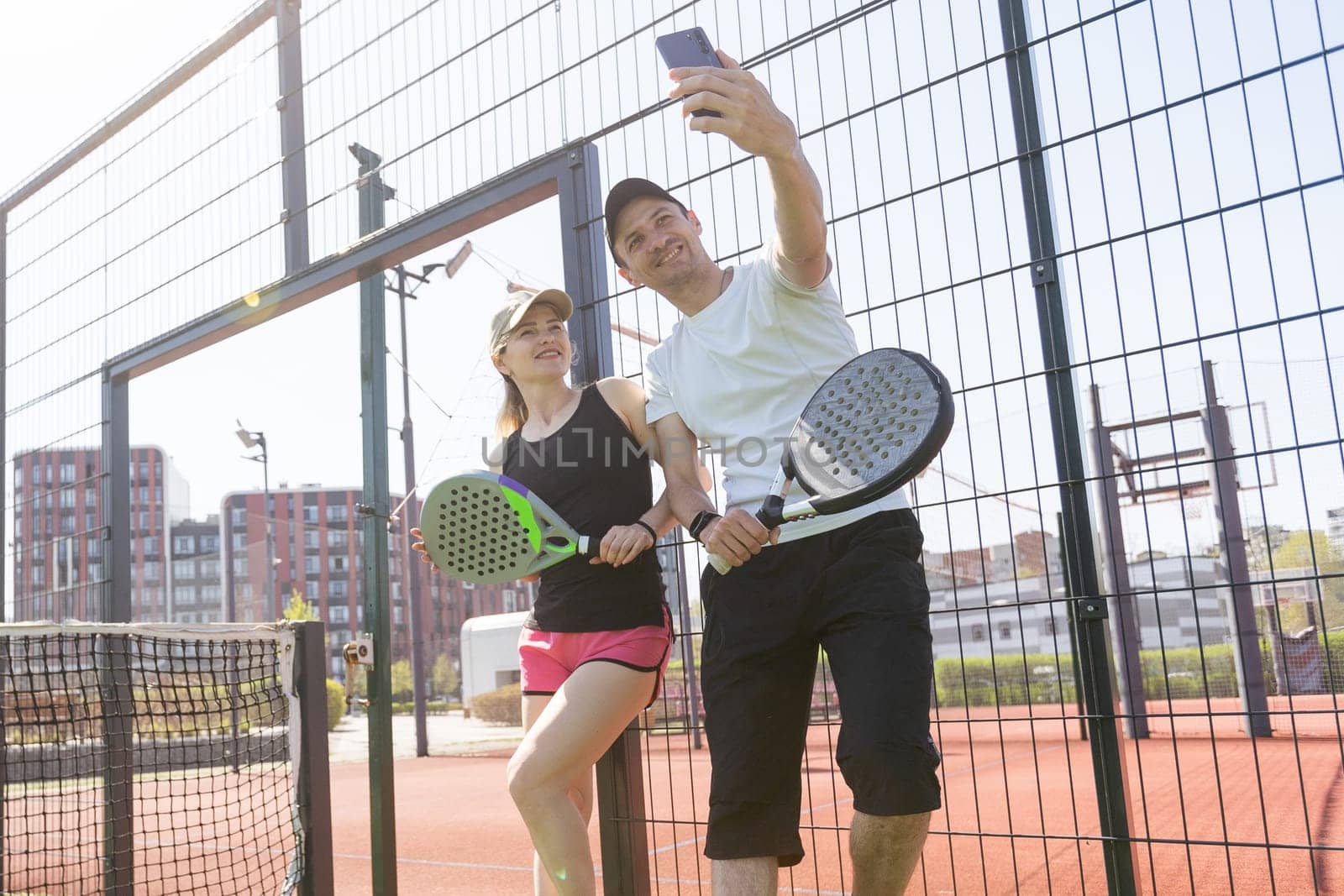 young woman playing Padel Tennis with partner in the open air tennis court. High quality photo