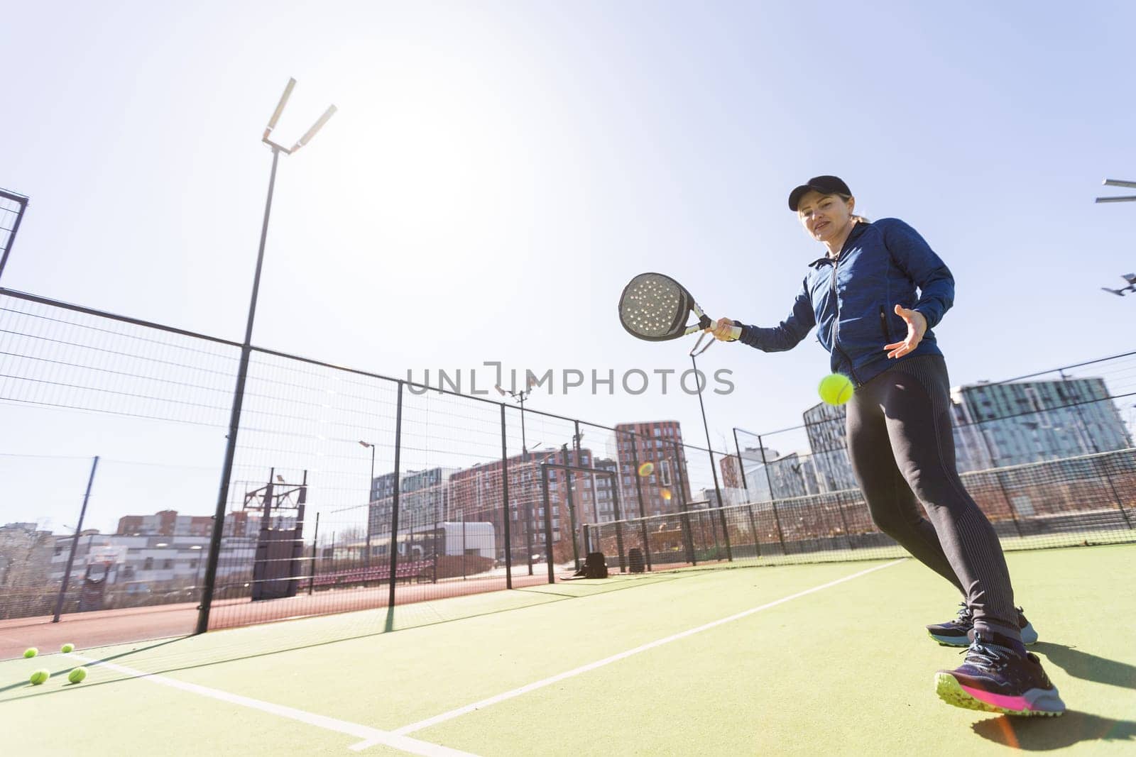 woman playing paddle tennis outdoors. by Andelov13