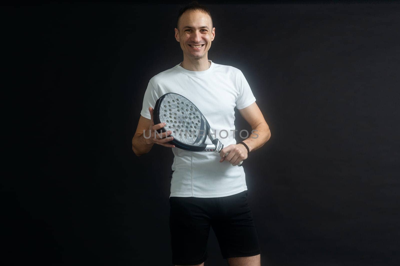 Padel Tennis Player with Racket in Hands. Paddle tennis, on a black background. High quality photo