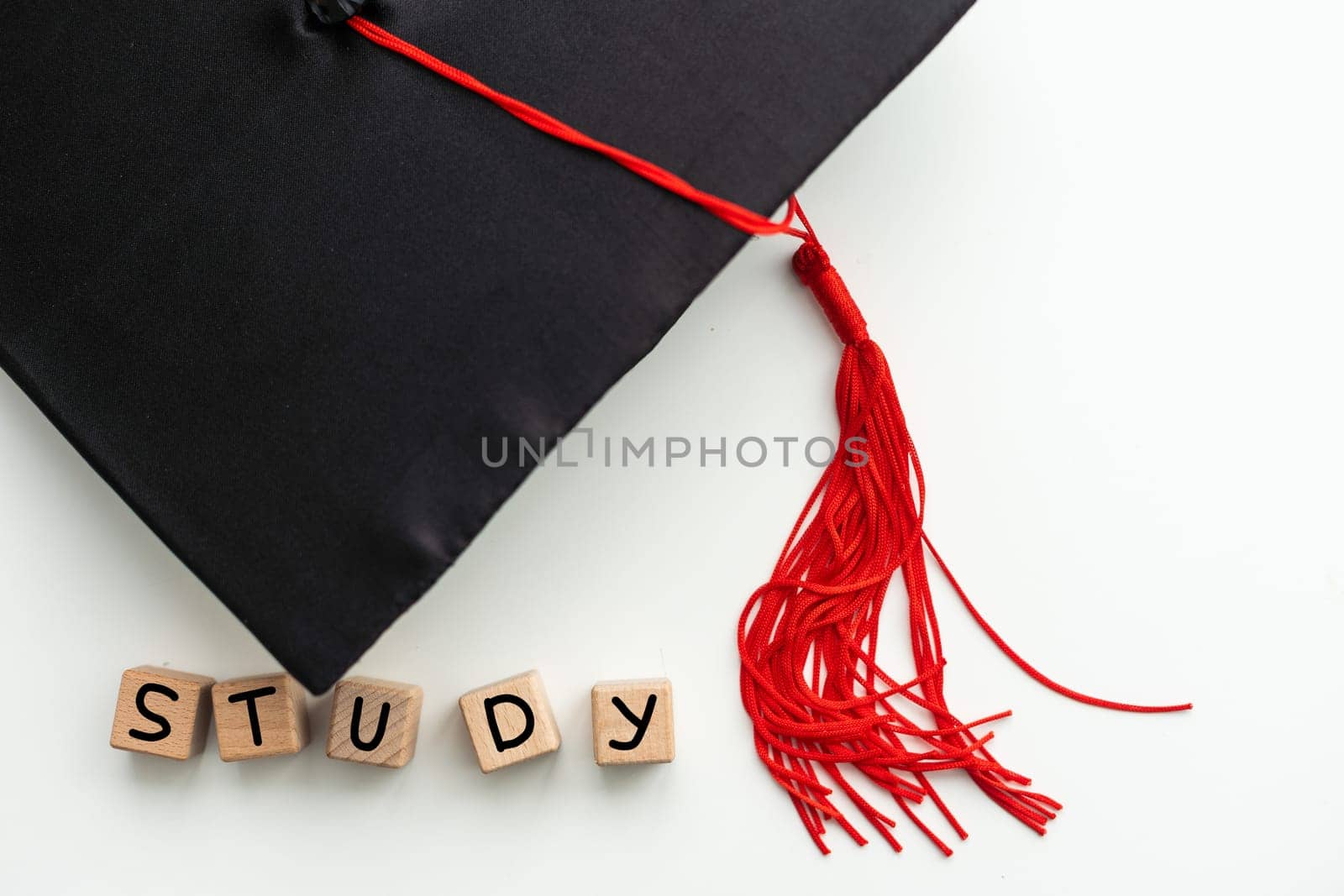 Graduation cap with red tassel isolated on white background by Andelov13