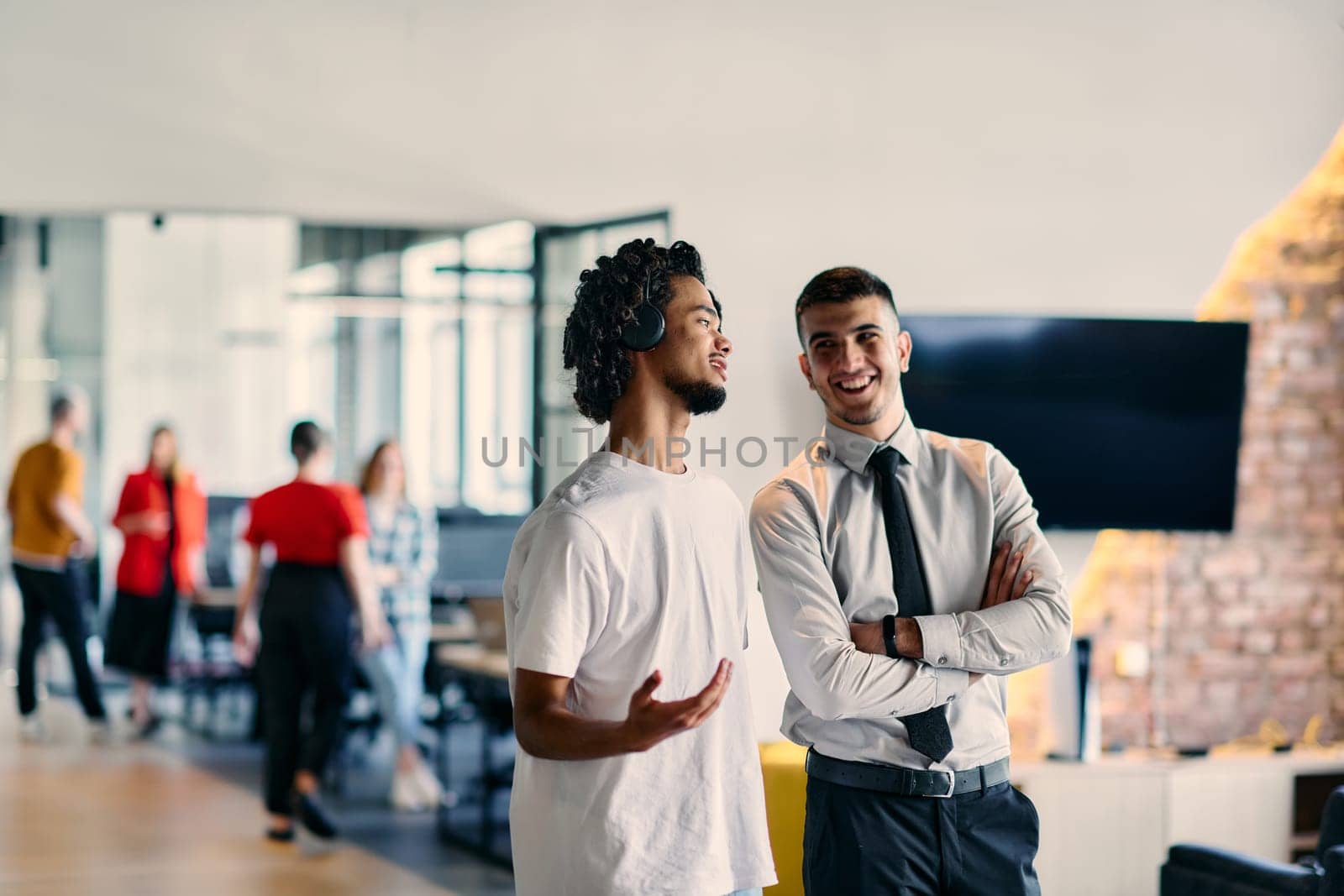 A group of colleagues, including an African American businessman and a young leader in a shirt and tie, pose together in a modern coworking center office, representing a dynamic blend of professionalism and collaboration.