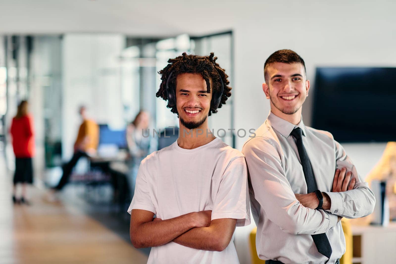 A group of colleagues, including an African American businessman and a young leader in a shirt and tie, pose together in a modern coworking center office, representing a dynamic blend of professionalism and collaboration.