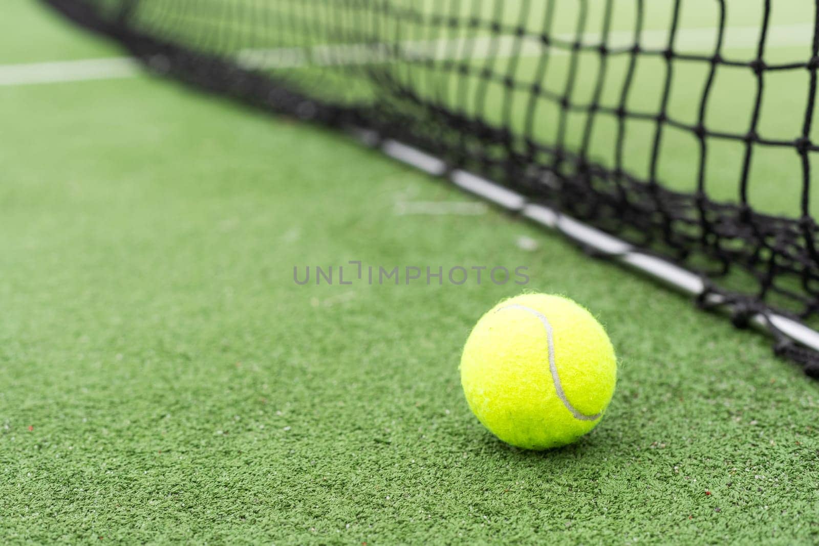 Tennis Ball on the Court against the Court Net. High quality photo