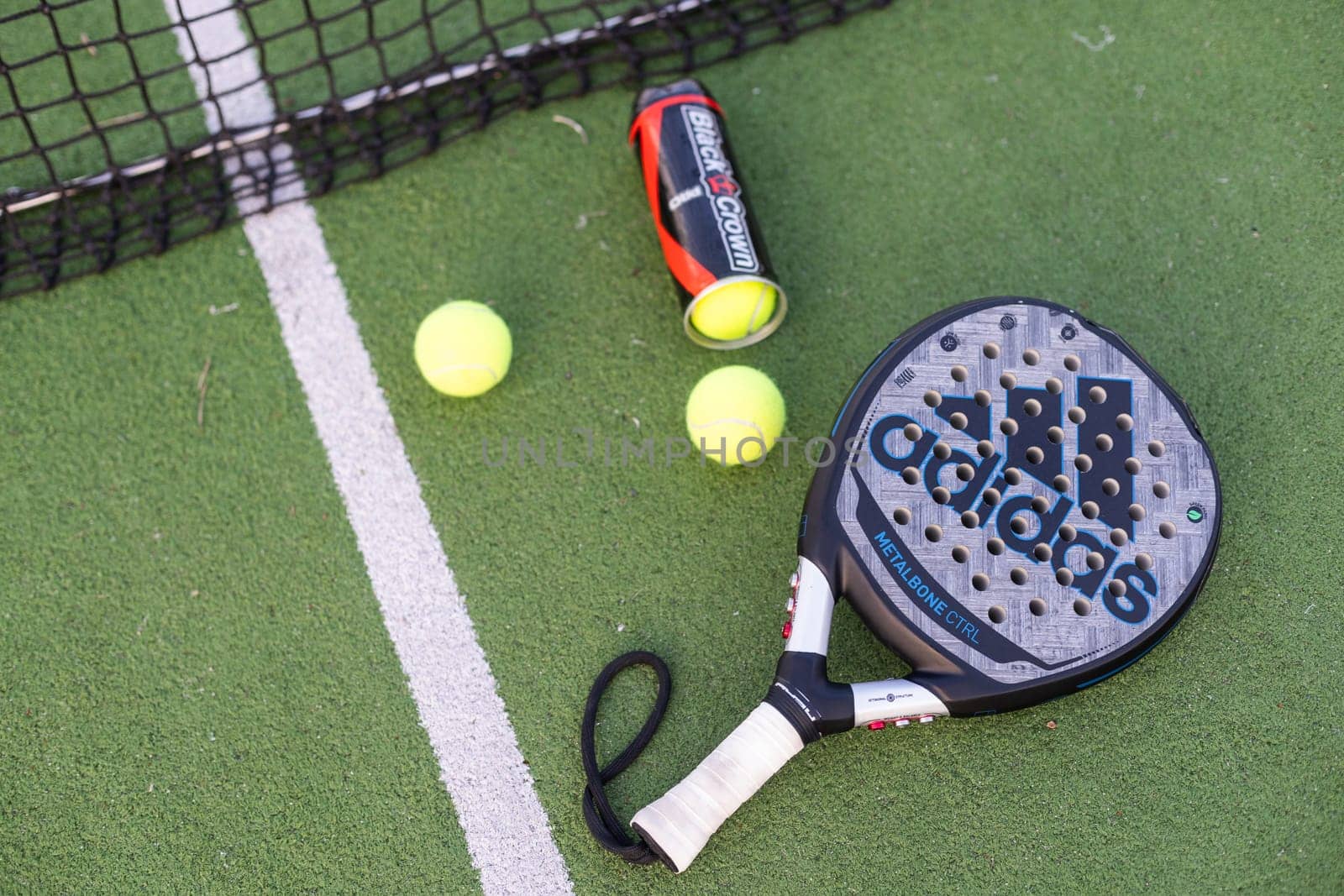 Ukraine Kyiv, 30.03.2024: Padel racket adidas and padel ball on a green court. High quality photo