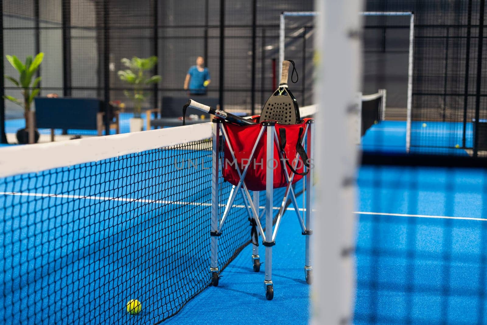 Paddle tennis rackets, balls and basket in court still life. High quality photo