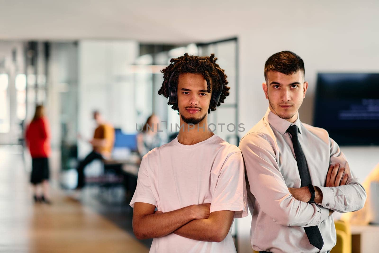 A group of colleagues, including an African American businessman and a young leader in a shirt and tie, pose together in a modern coworking center office, representing a dynamic blend of professionalism and collaboration.