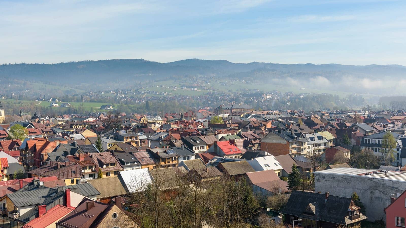Panoramic view of the rooftops of Nowy Targ with the morning fog in the background
