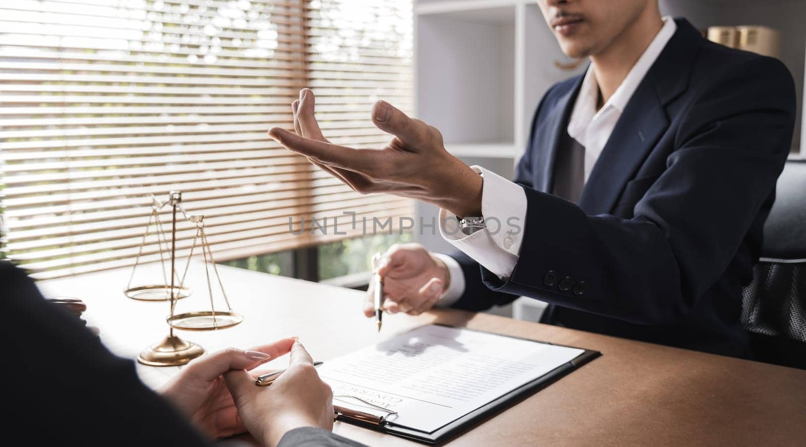Close-up of lawyer and businesswoman signing legal documents of doing business in lawyer's office room.