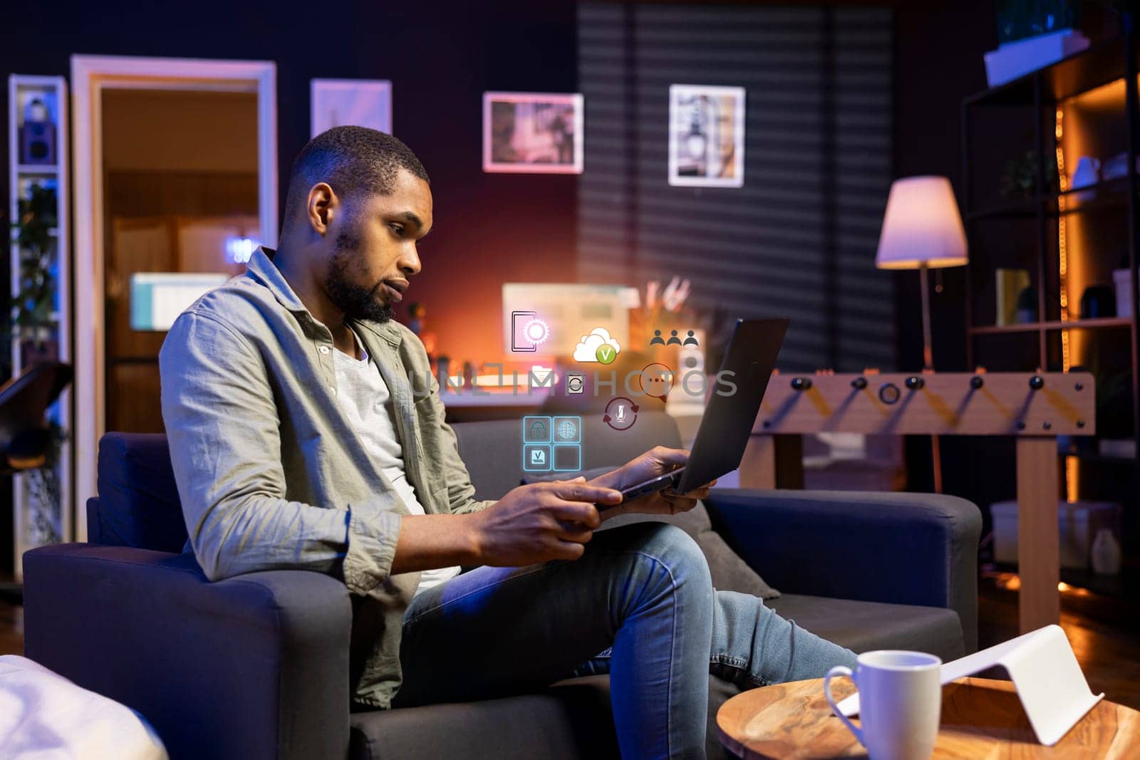 African american man working from home on laptop, solving tasks, online connectivity concept. Remote employee using AR technology to interact with notebook programs software