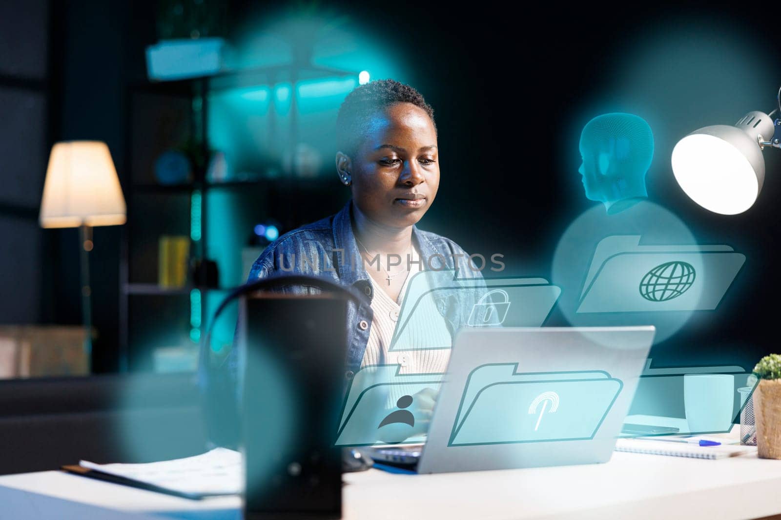 African american woman using laptop, interacting with artificial intelligence assistant using AR tech. BIPOC person working with AR technology, giving commands to virtual AI companion