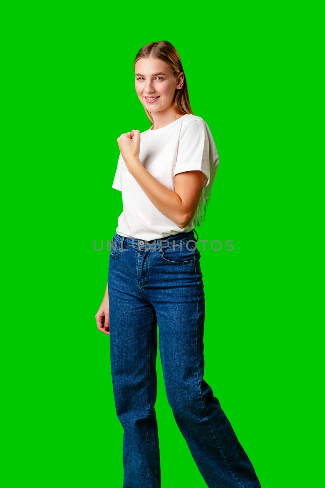 Happy Young Woman Raising Fists against green background in studio