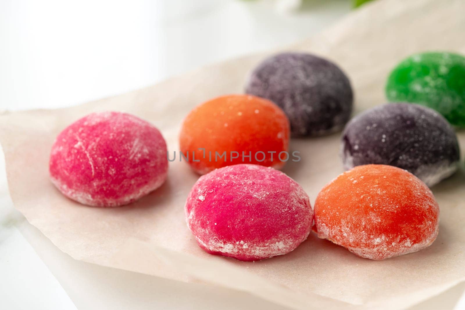 Multi-colored Japanese cakes Mochi in a white plate by Fabrikasimf