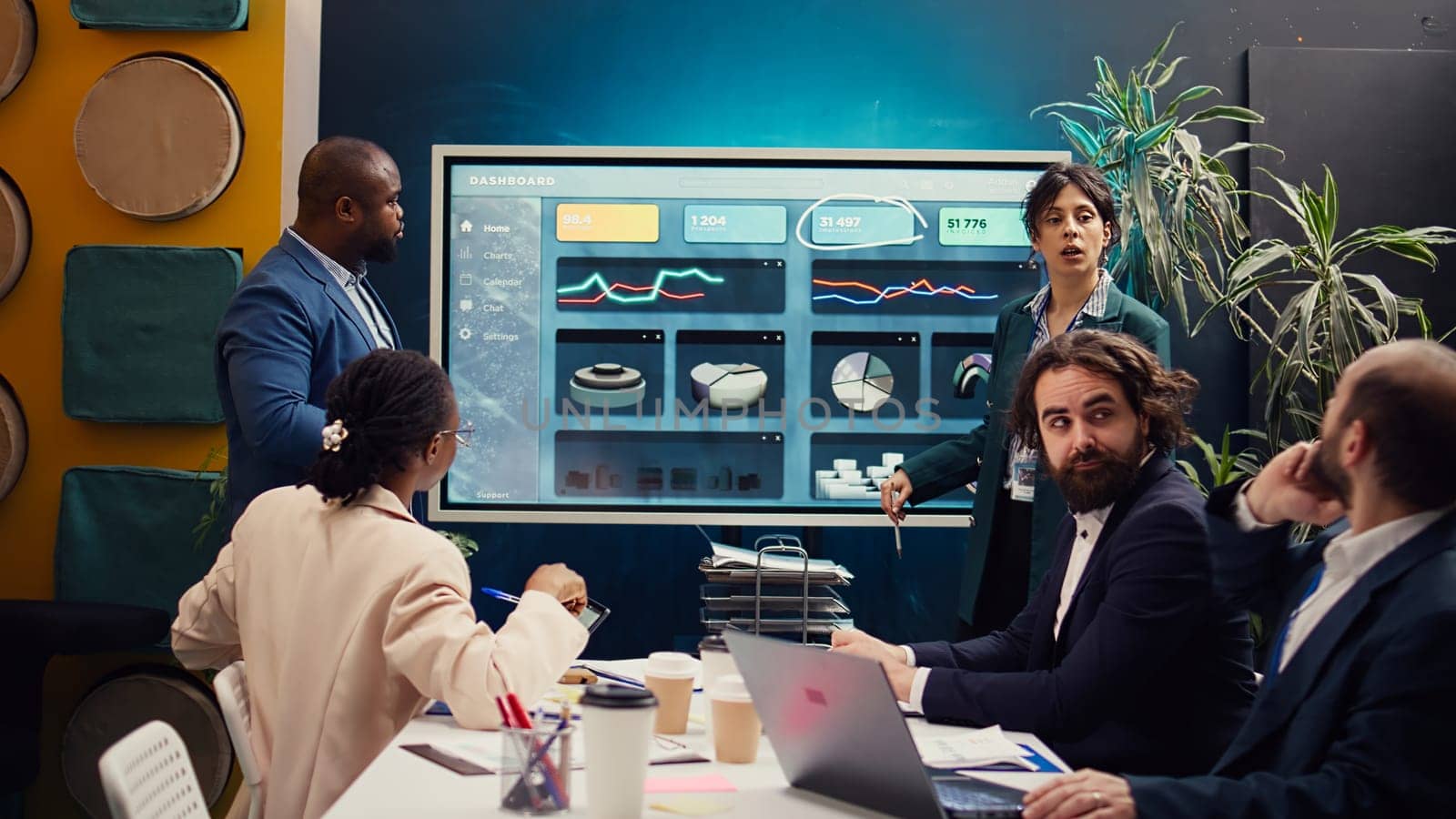 Startup team reviewing the organization position within the market, conducting an analysis or benchmarking exercises. Enterprise colleagues discuss activities for organizational growth. Camera B.