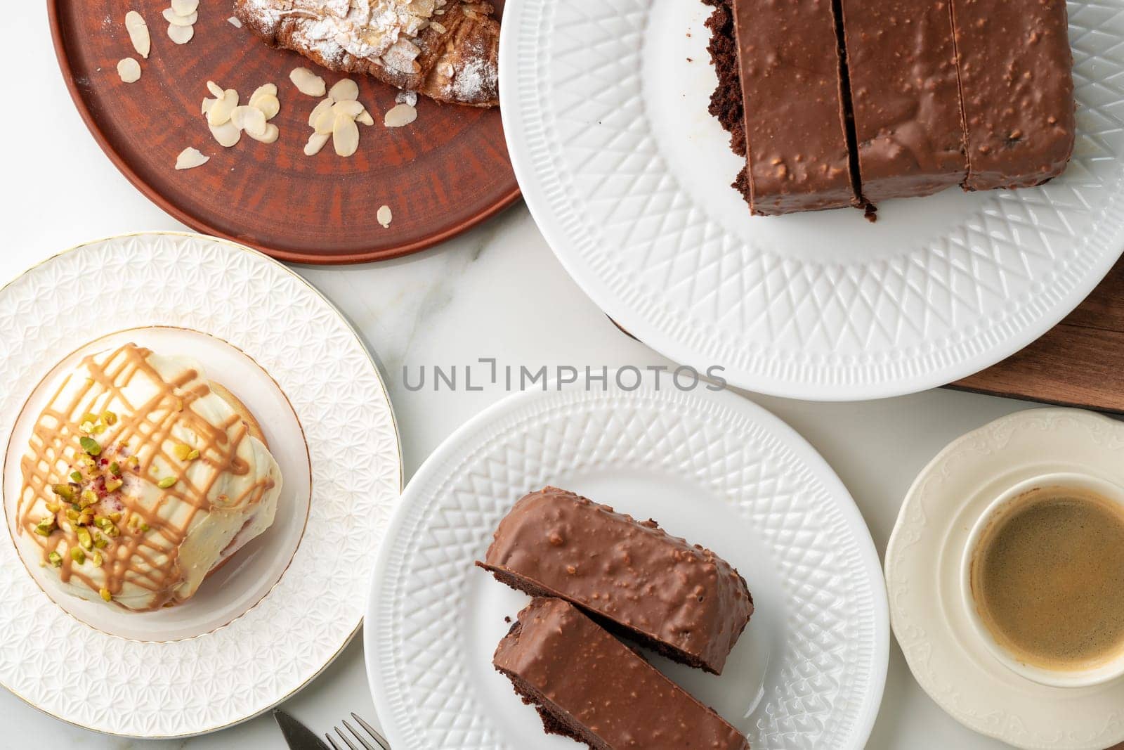 Homemade desserts sponge cake and cinnamon bun on table by Fabrikasimf