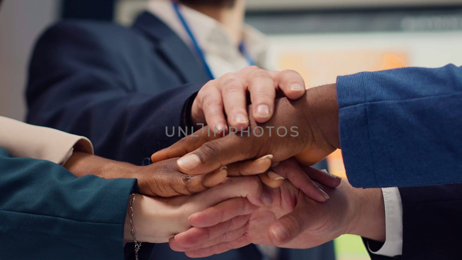 Business affiliates connecting hands and raising them up in celebration by DCStudio