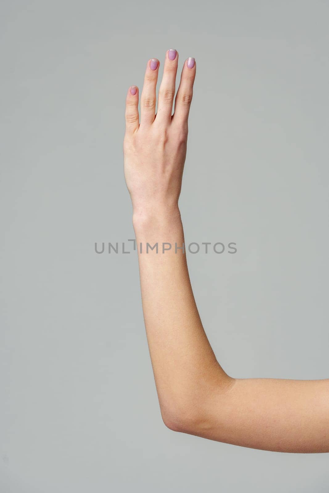 Female hand gesturing numbers on gray background by Fabrikasimf