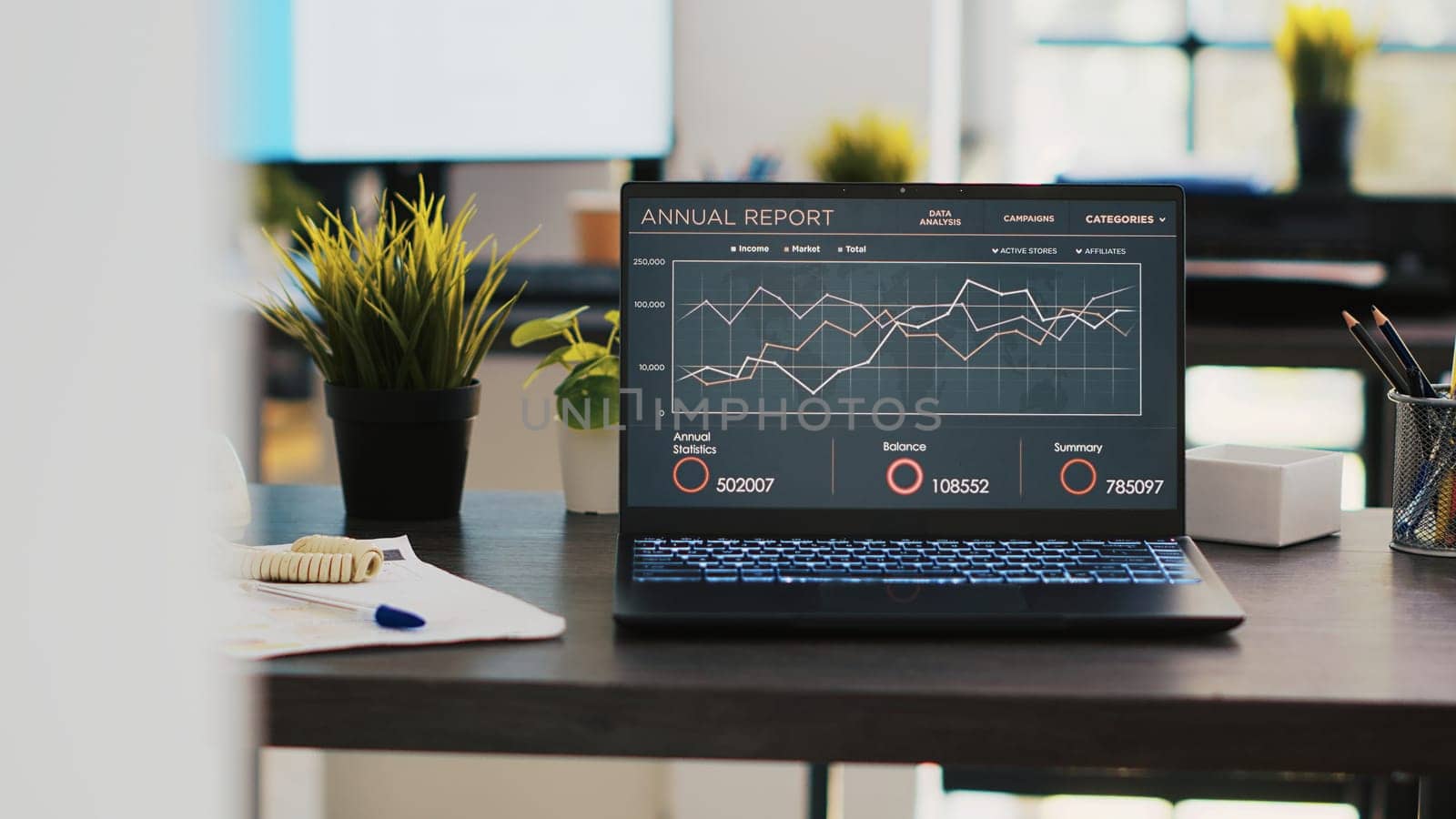 Business graphs and figures on laptop left open on desk in empty workspace. Economic annual report charts on notebook screen in company financial department office, panning shot