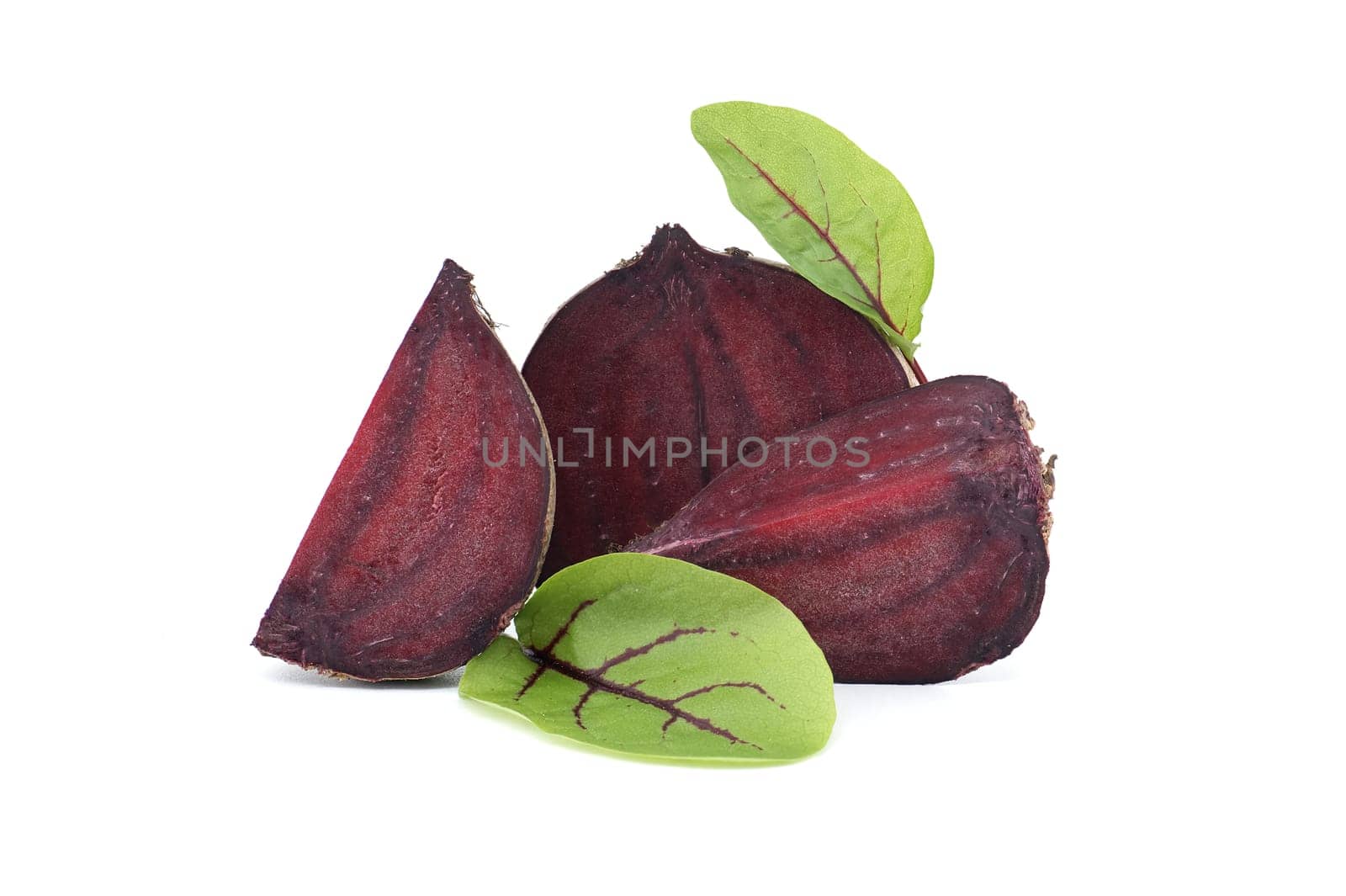 Slices of beetroot revealing their vibrant purple interiors complete with their fresh green leaves isolated on white background
