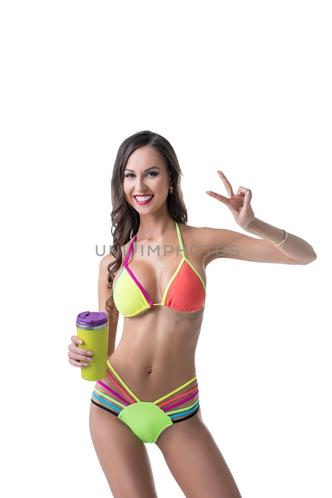 Charming sporty woman in bright bikini posing with shaker