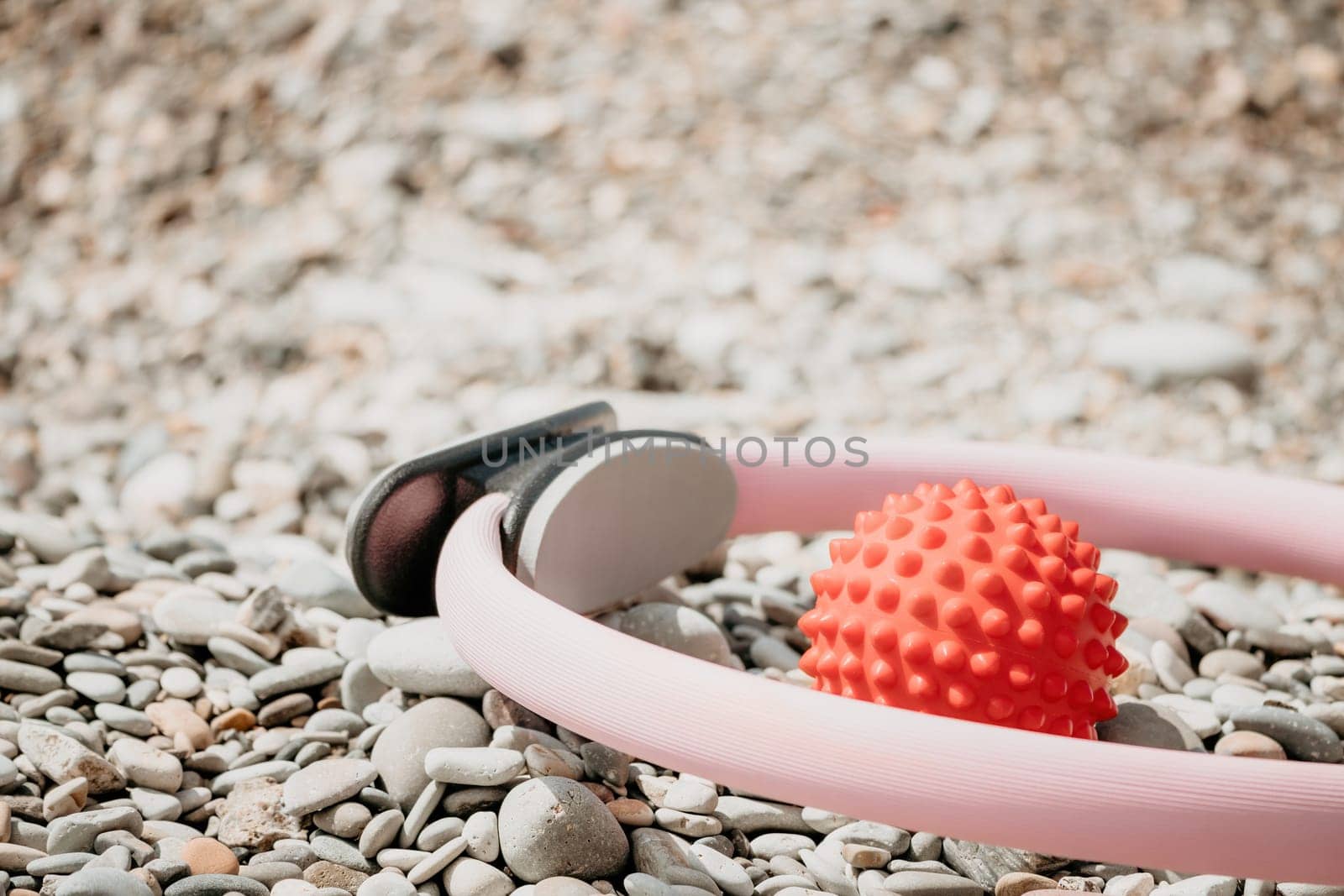 Pilates magic ring and rubber band on yoga mat near sea. Female fitness yoga concept. Healthy lifestyle harmony and meditation. by panophotograph