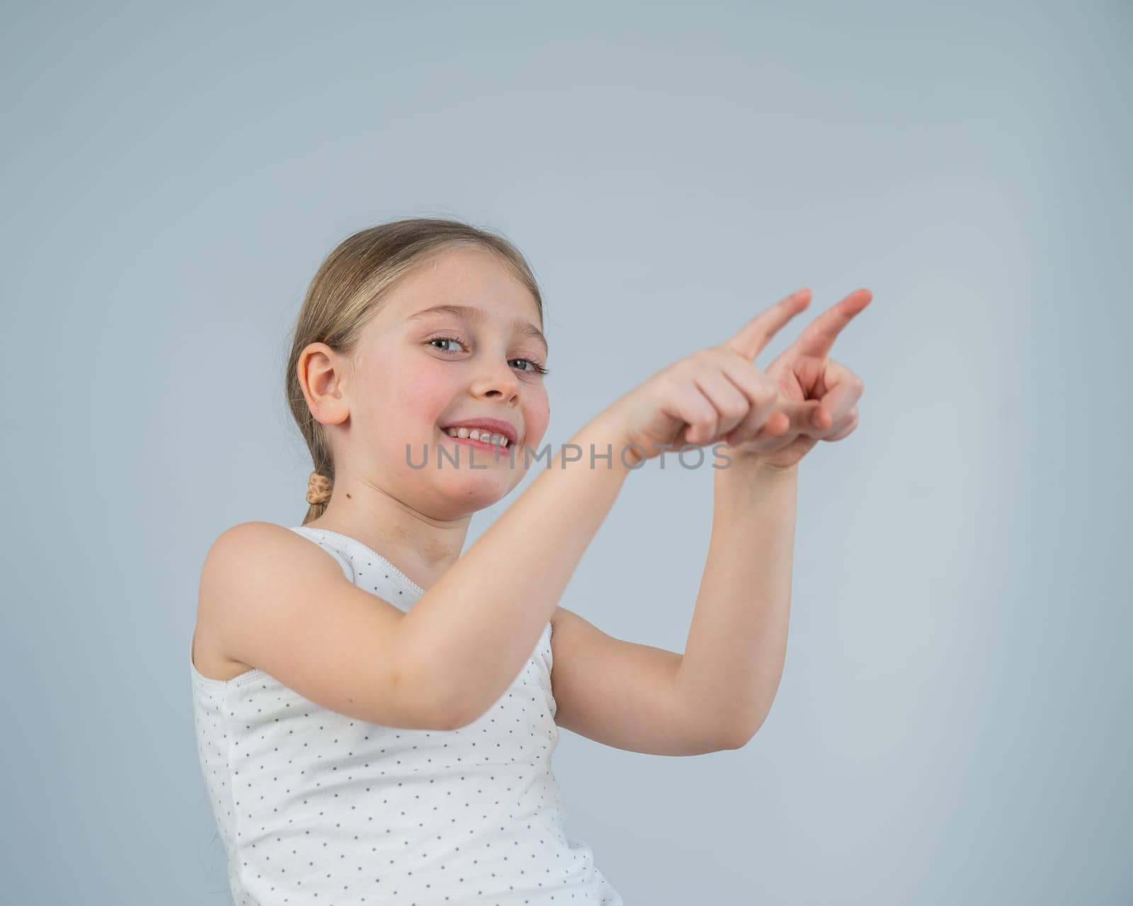 Little Caucasian girl having fun and pointing with fingers on white background. by mrwed54