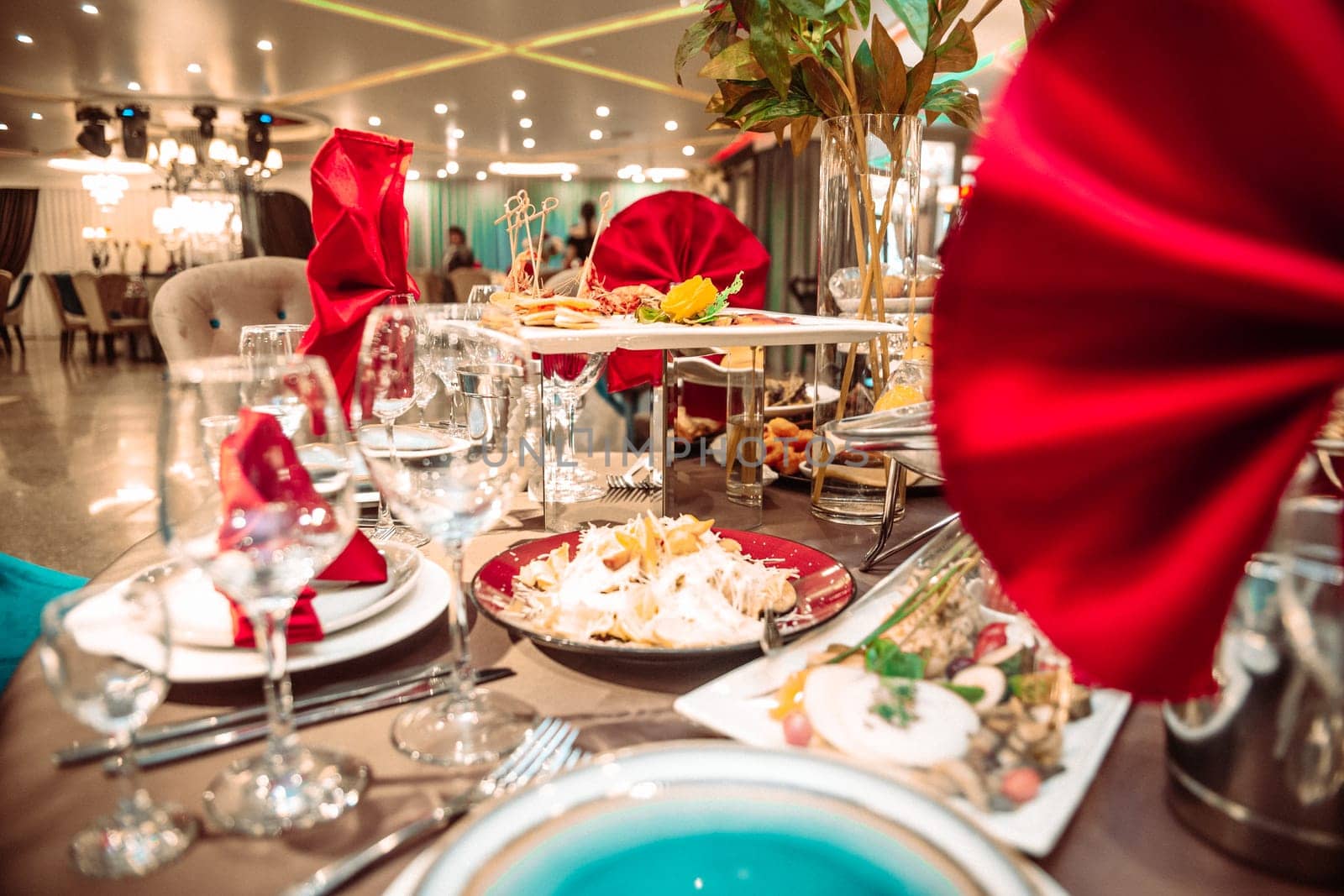 a table in a restaurant on a holiday with bright red napkins by Pukhovskiy