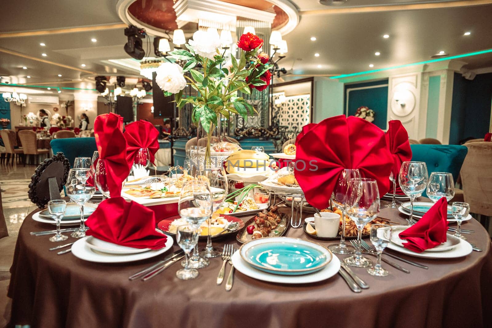 a table in a restaurant on a holiday with bright red napkins.