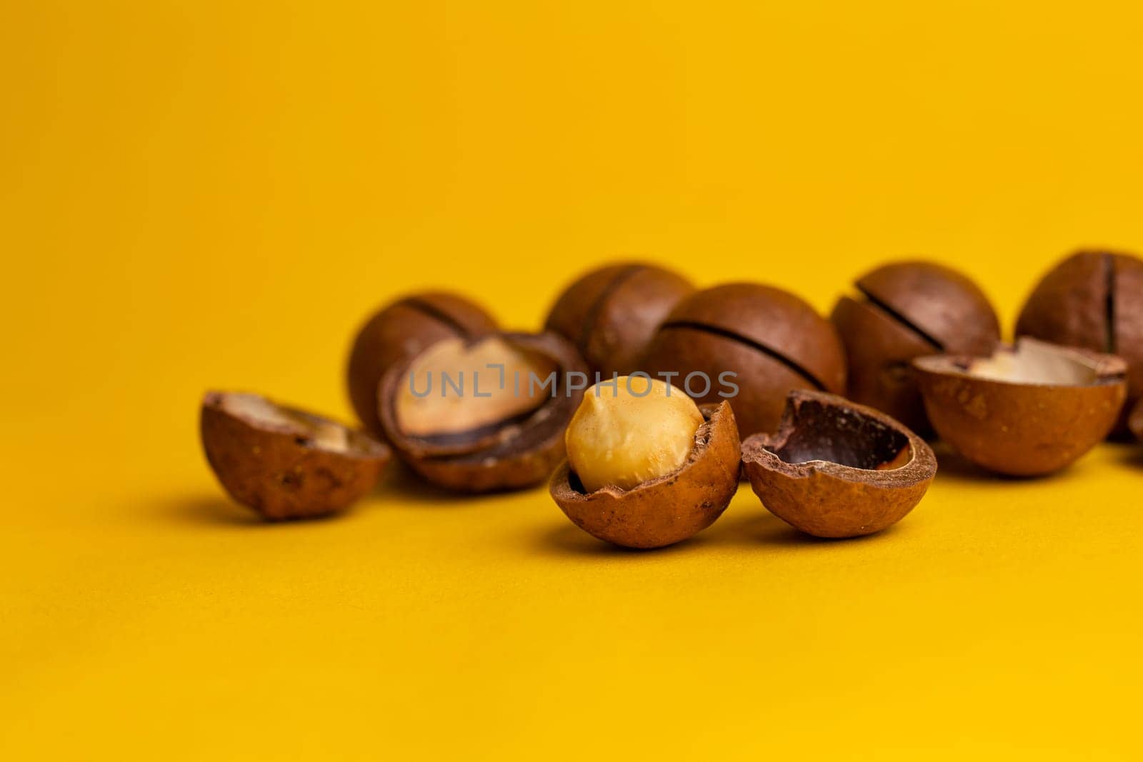 delicious macadamia nuts on a yellow background.