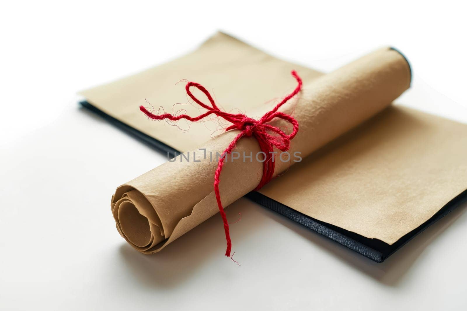 Roll of paper with red string tied around it. Generative AI.
