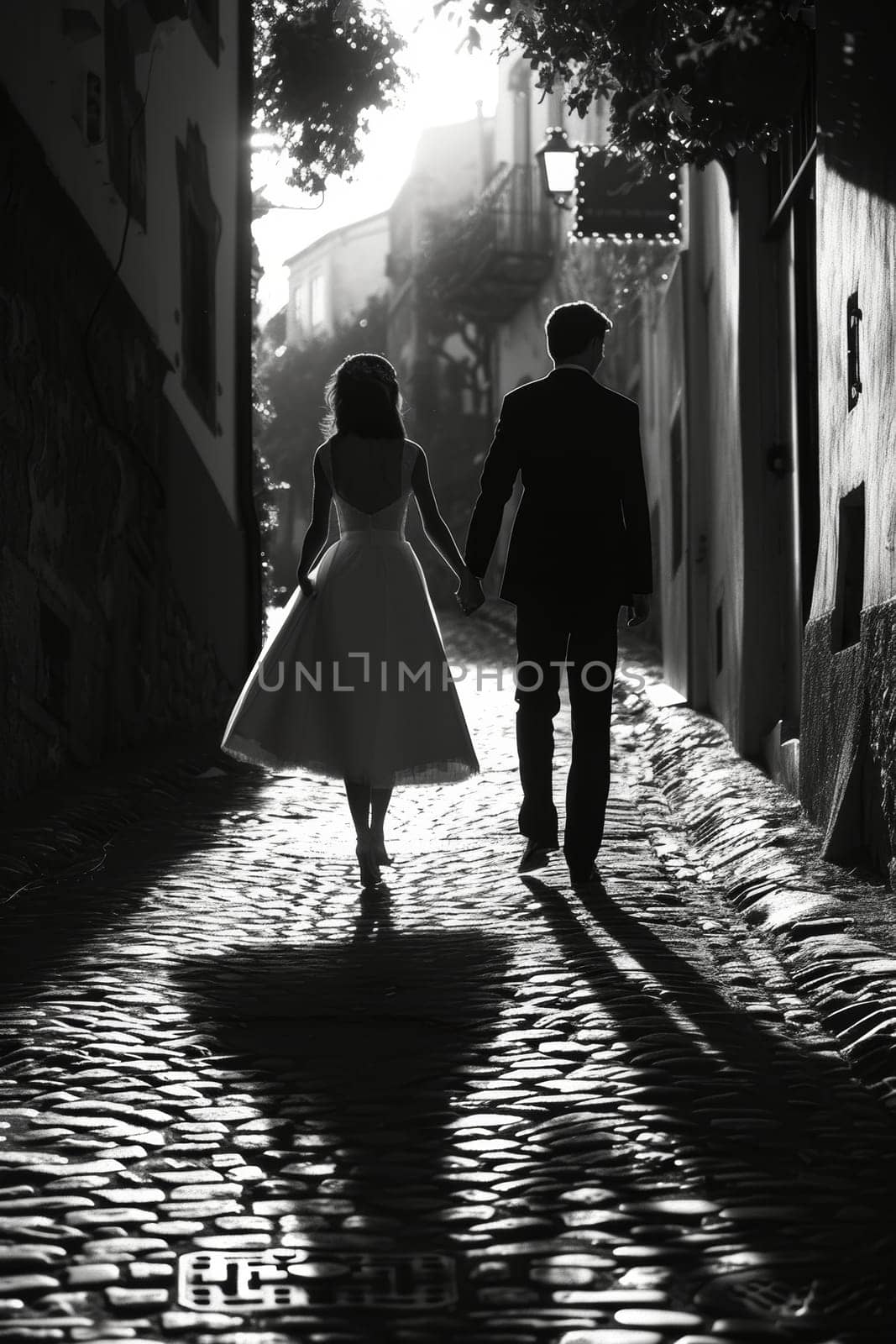 Black and white image of bride and groom holding hands and walking on a cobblestone street, capturing a moment of marital bliss. by sfinks