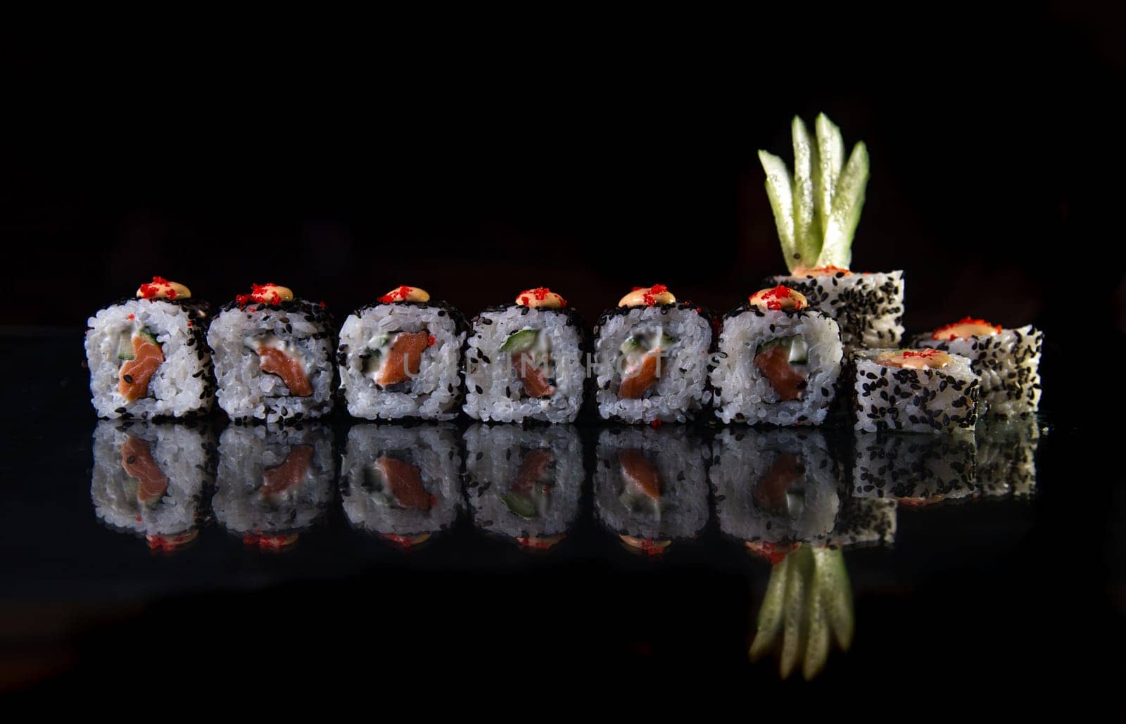 sushi with fish and chia seeds on a black background.