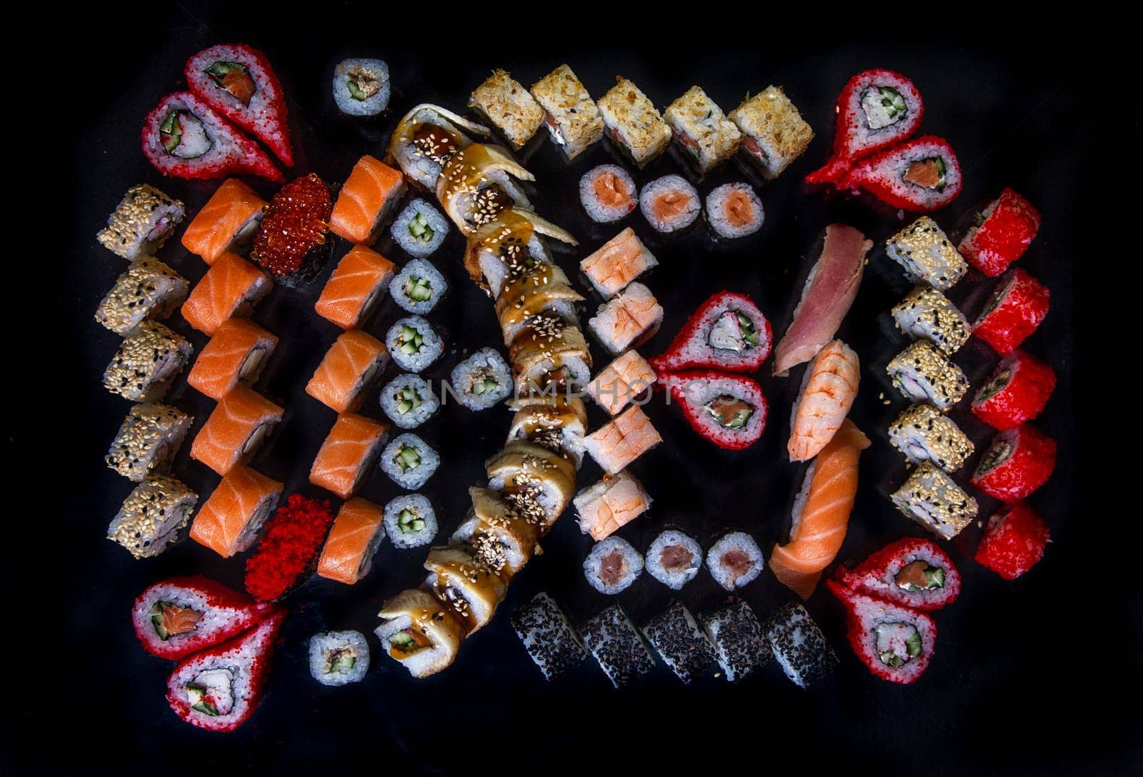large set sushi and rolls japanese cuisine top view on black background by Pukhovskiy