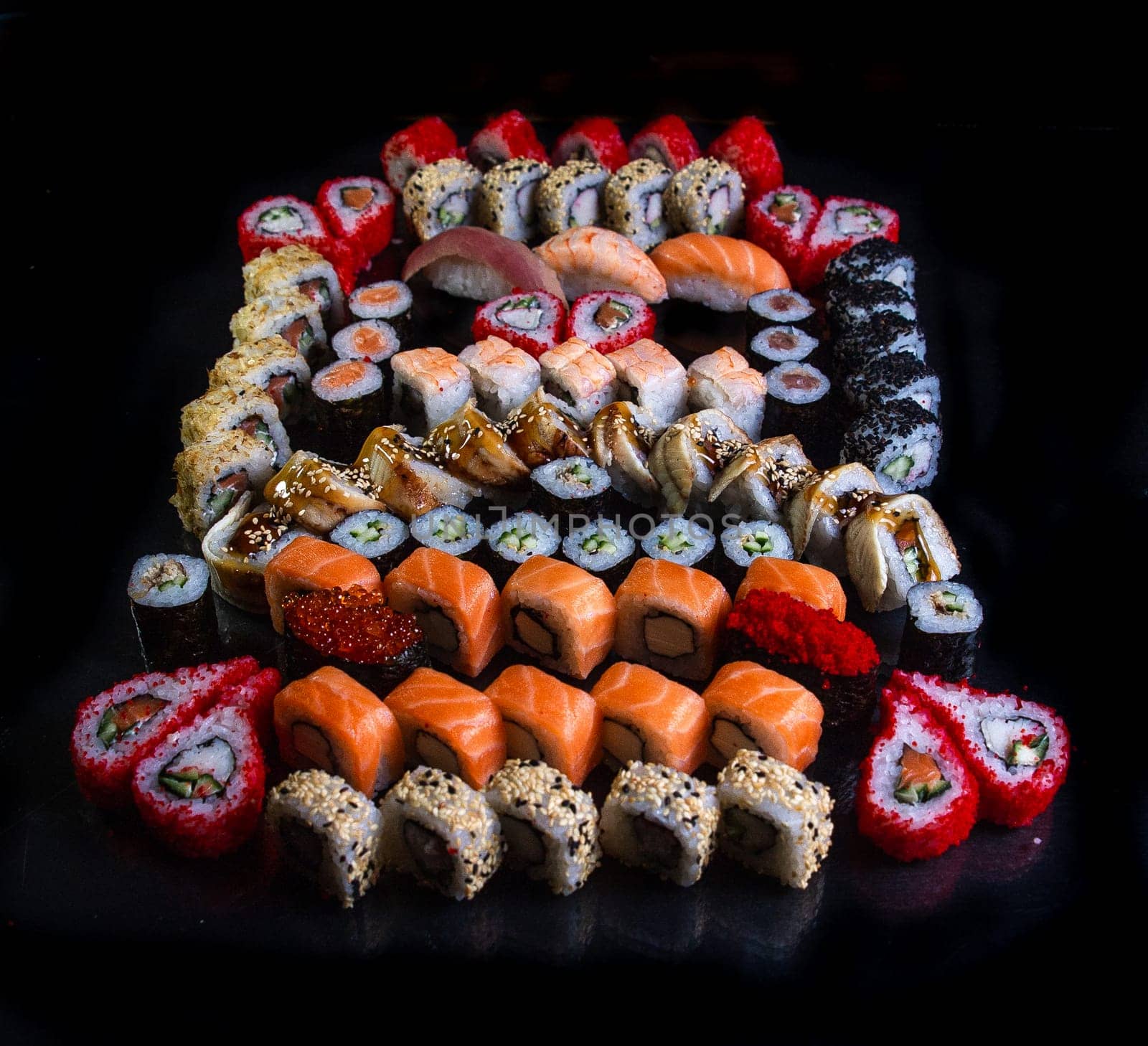 large set of Japanese cuisine for the company on a black background.