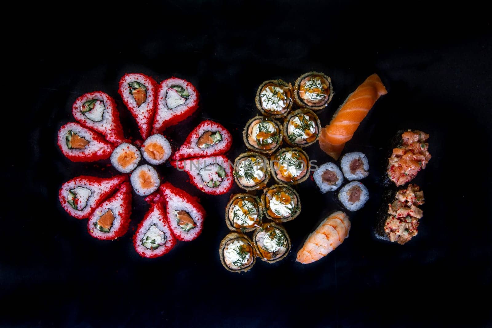 large set sushi and rolls japanese cuisine top view on black background.