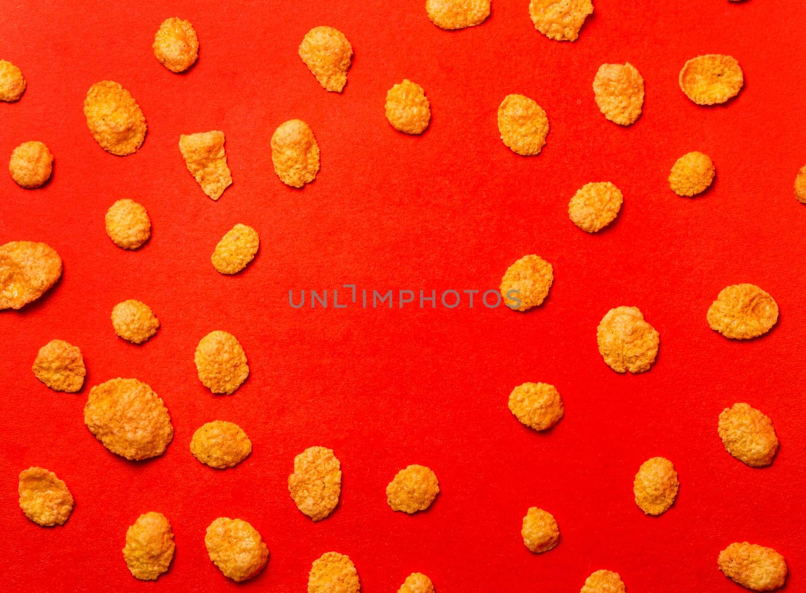 corn flakes on a red background top view by Pukhovskiy