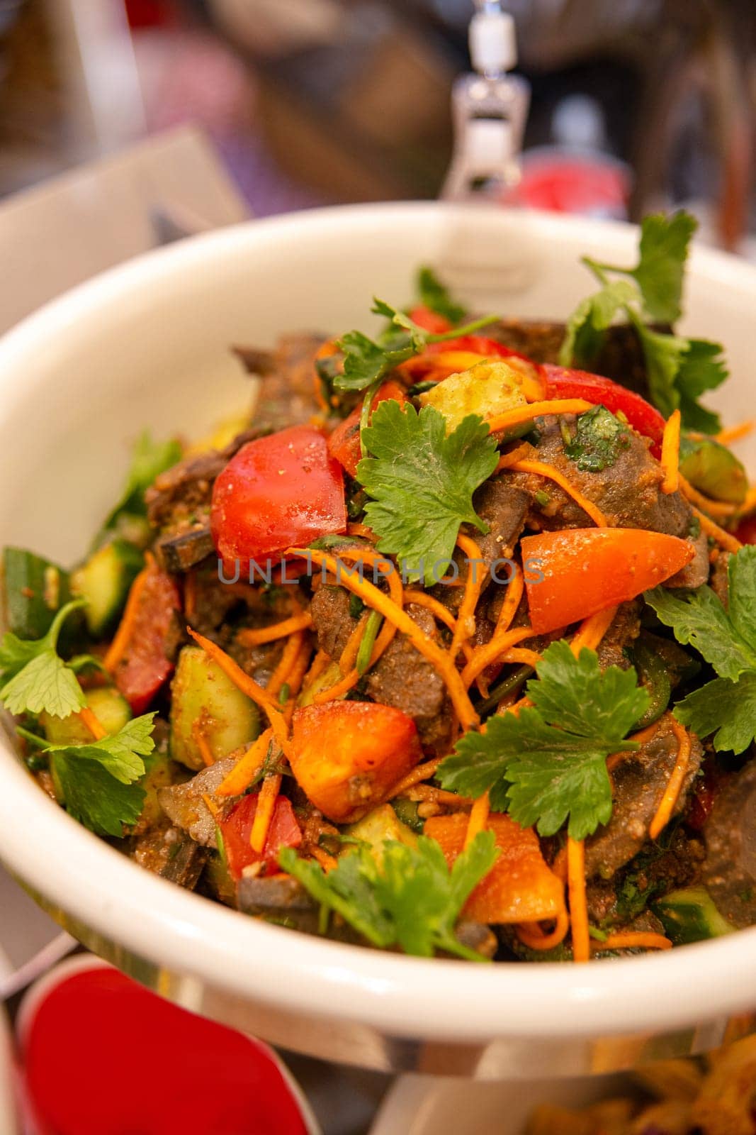 spicy meat with carrots, vegetables and herbs close-up