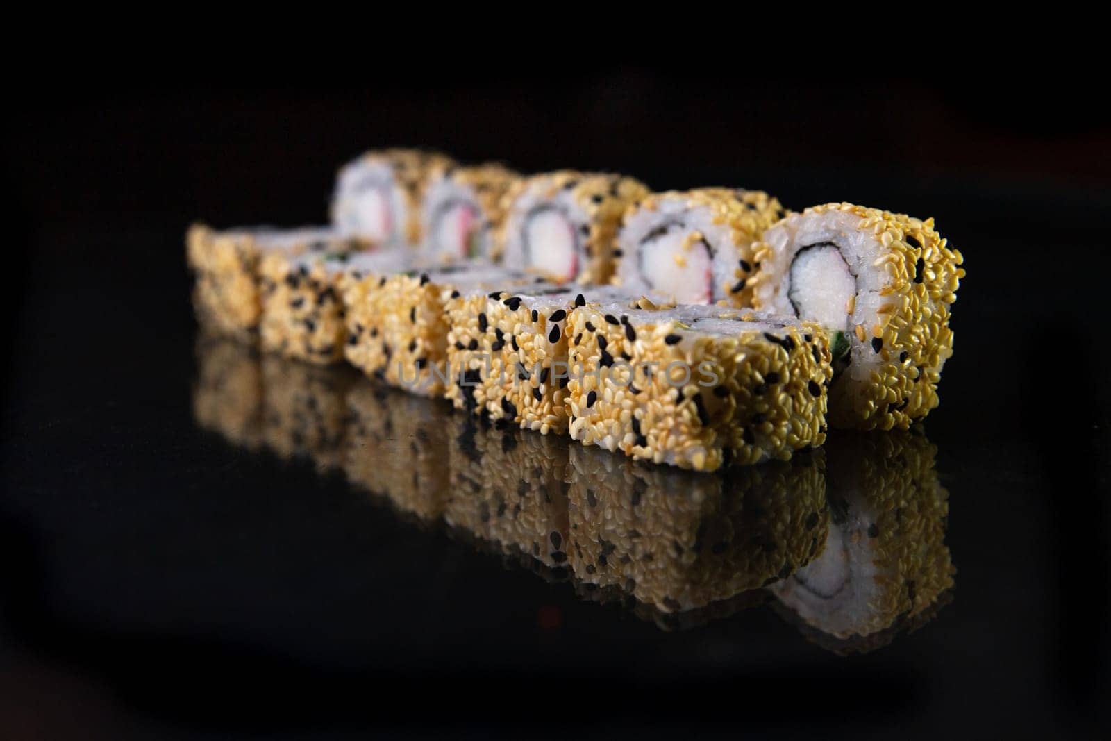 sesame rolls, reflected against a black background.