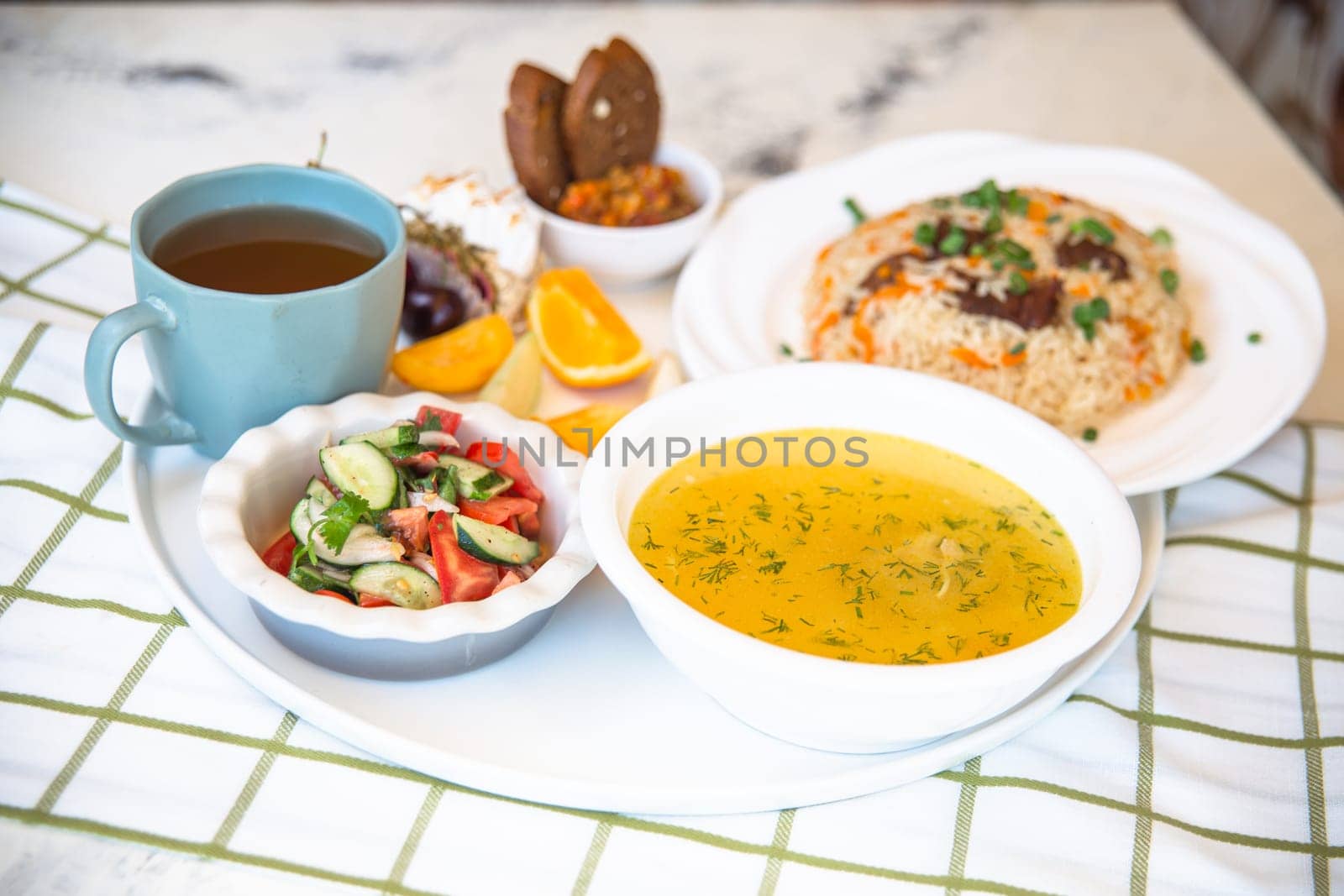 Business lunch in a cafe. set of soup and pilaf and tee