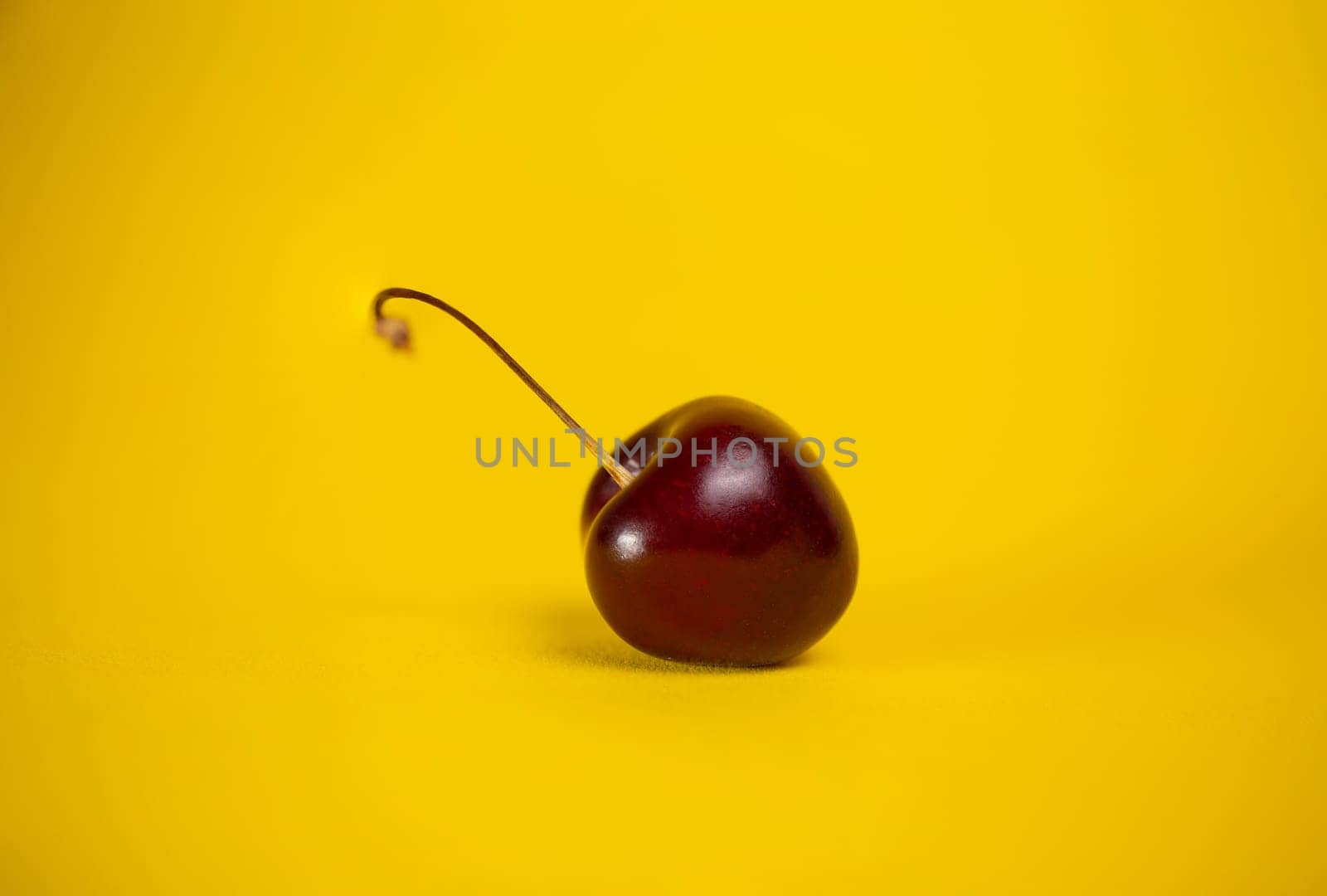 red cherry close-up on a yellow background