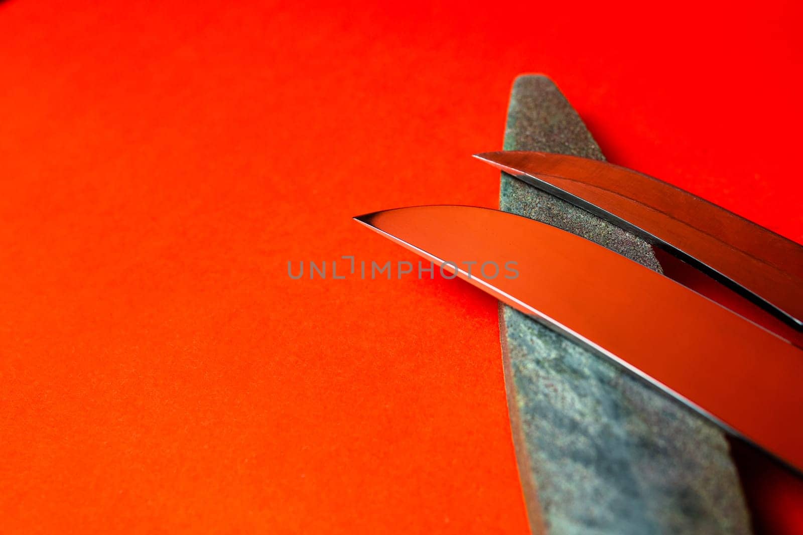 knife sharpening and stone for sharpening knives on a red background