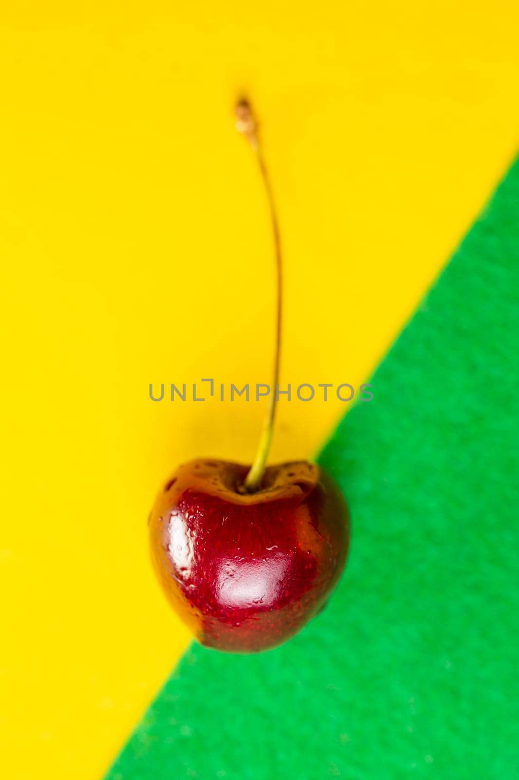 cherry in a close-up section on a yellow background by Pukhovskiy